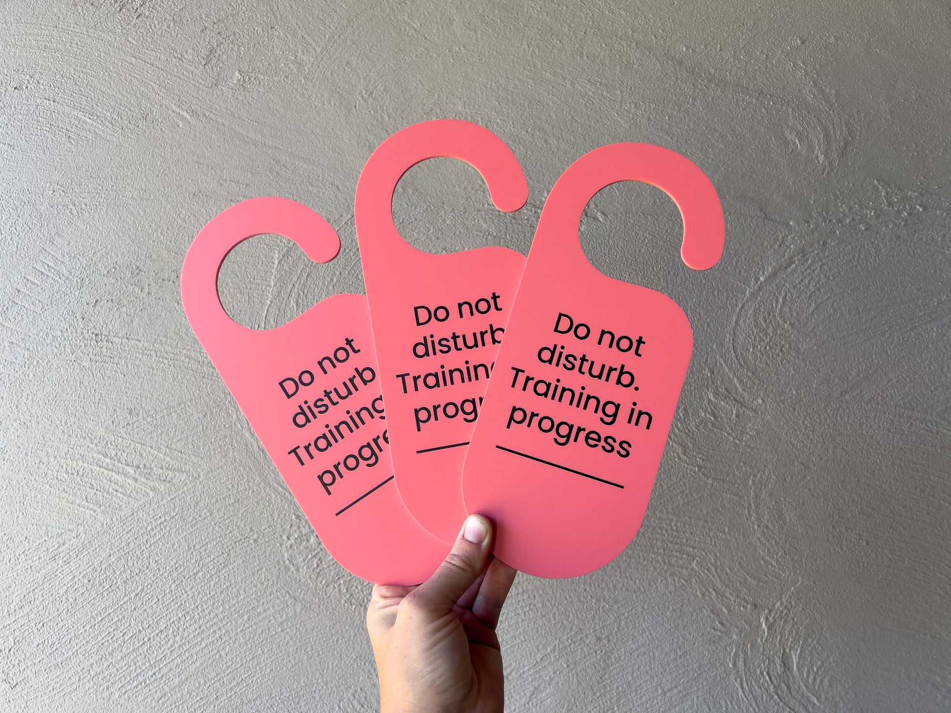 Bright salmon pink colour custom printed door hanger to display on the door when training sessions are in progress.