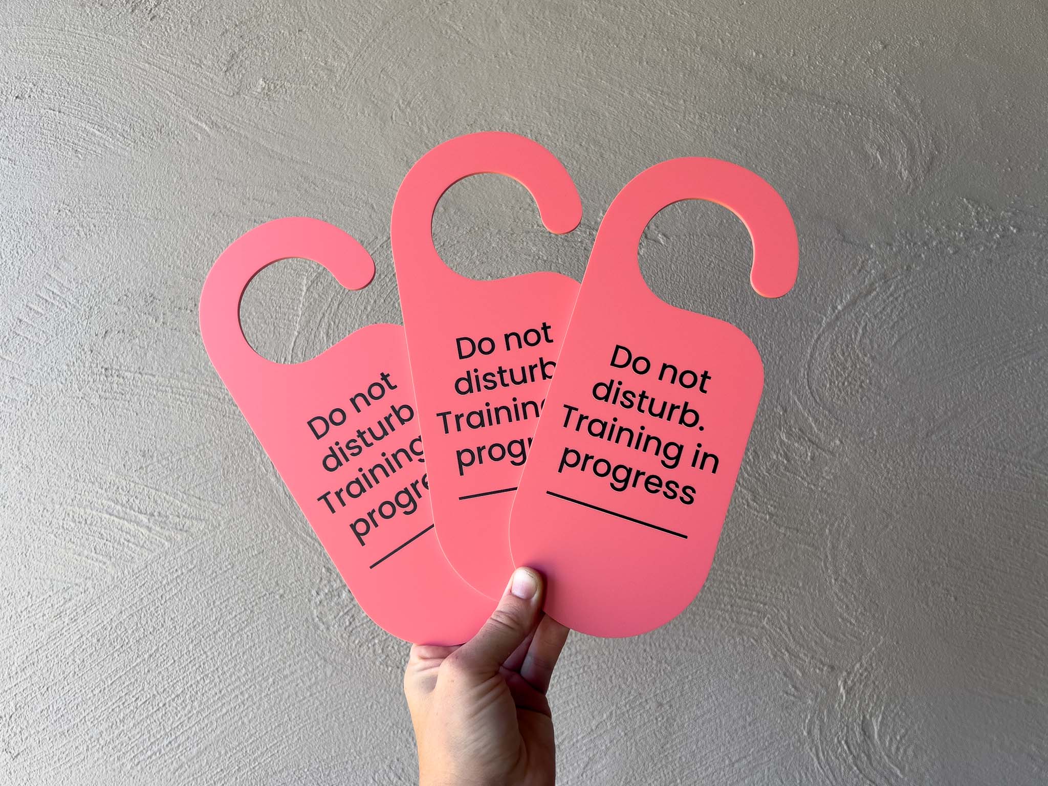Bright salmon pink colour custom printed door hanger to display on the door when training sessions are in progress.