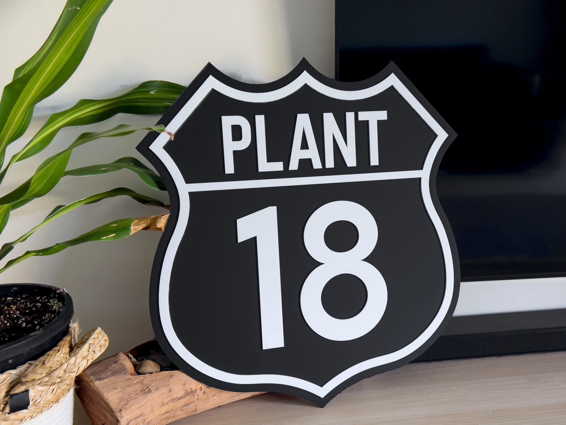 Decorative personalised classic retro sign shaped like a highway shield with 'PLANT 18' text in black and white.