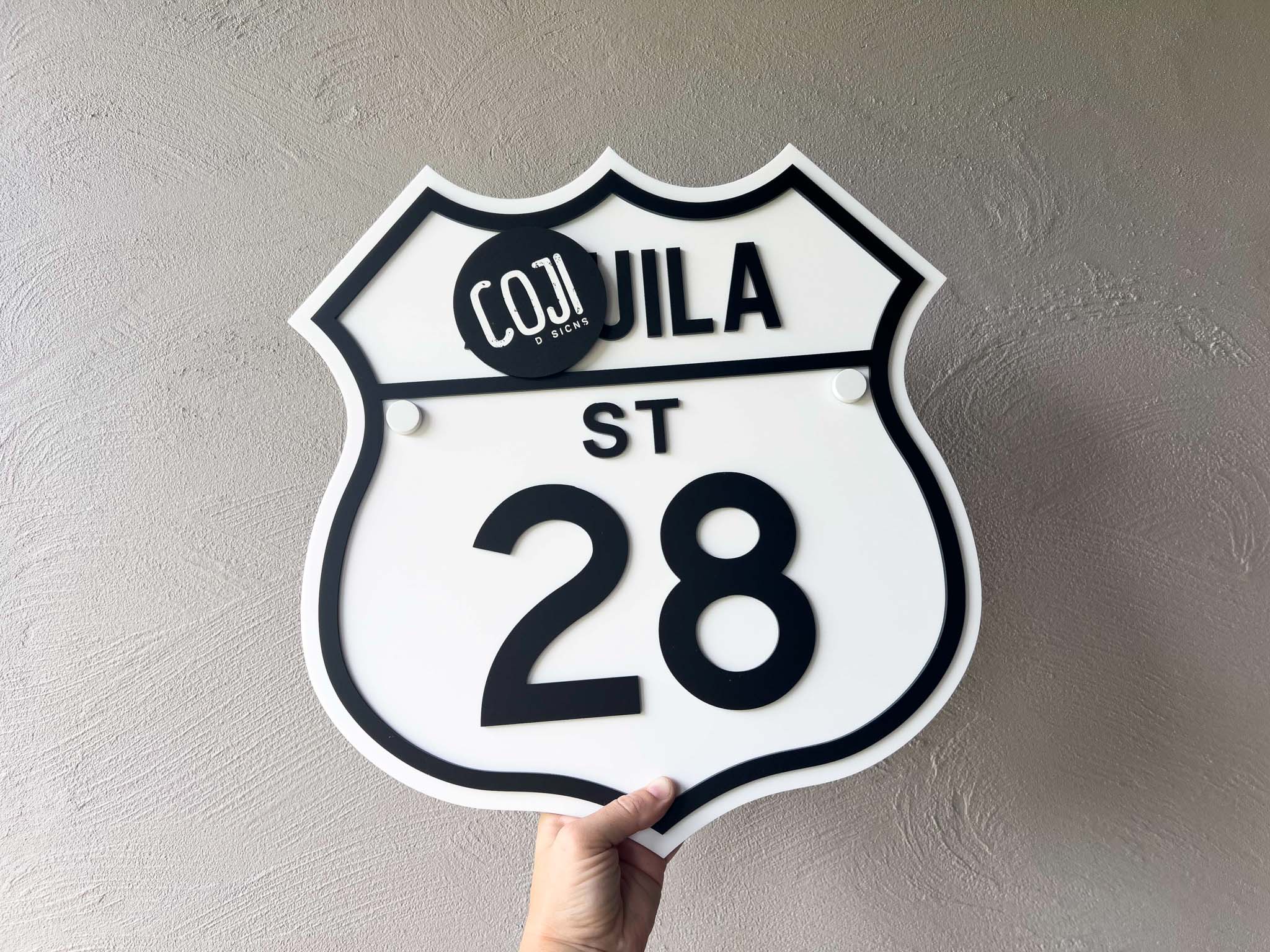 Decorative sign with '28 Cohuila St' text on a plain background | Coji Designs