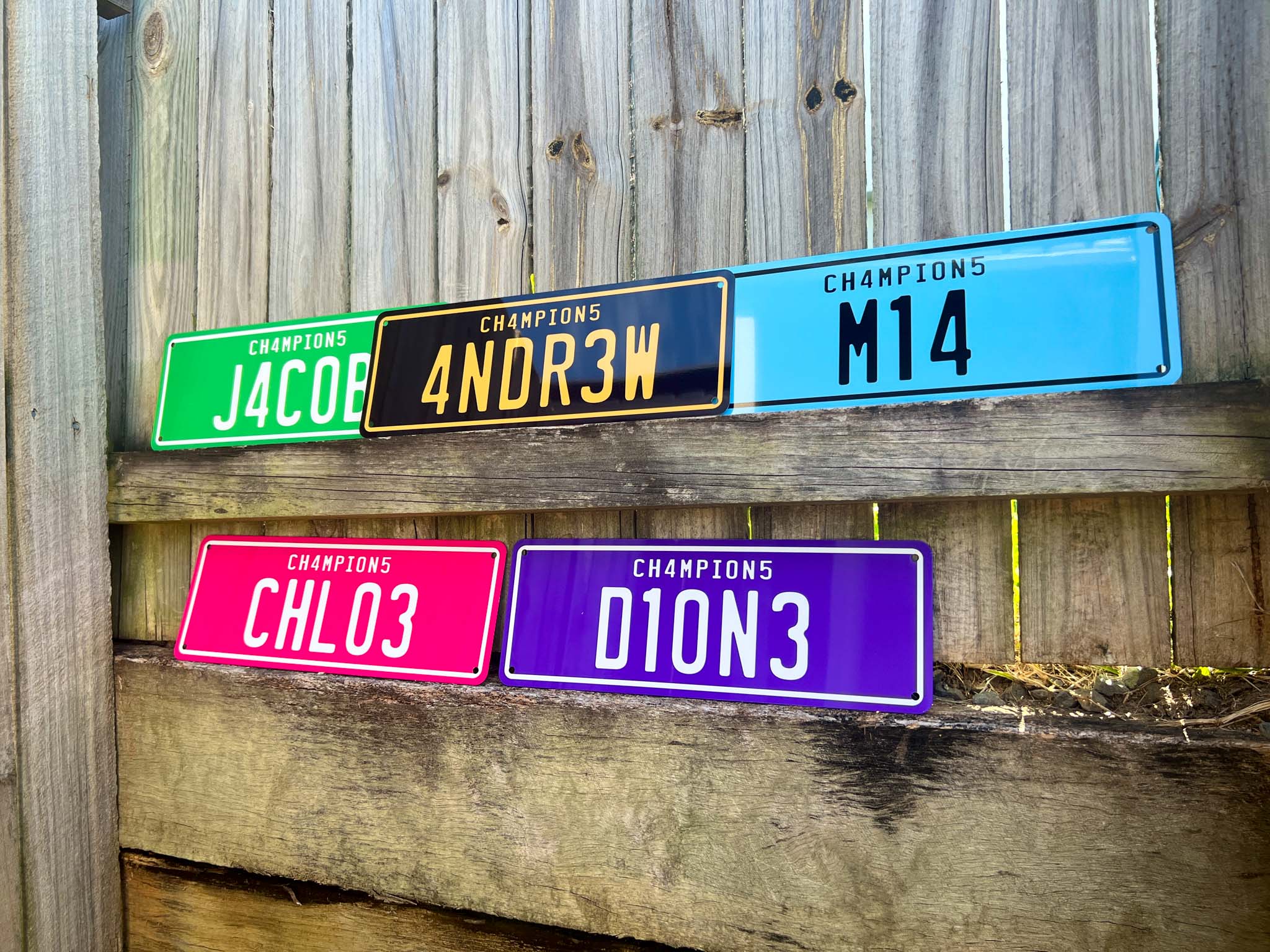 Colorful license plate-style signs with text on a wooden background
