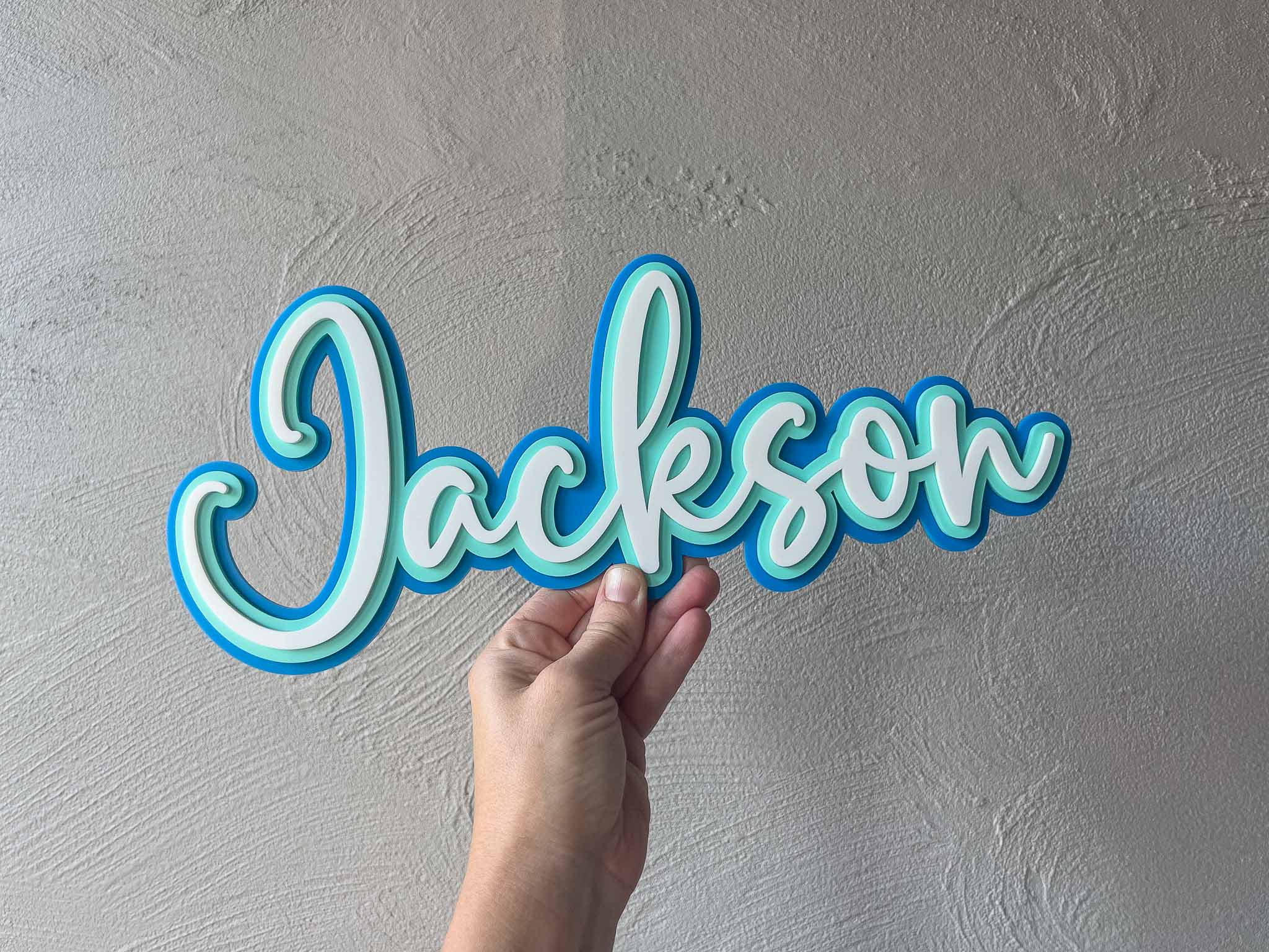 Colourful blue and mint green custom laser cut name plaque with 'Jackson'.