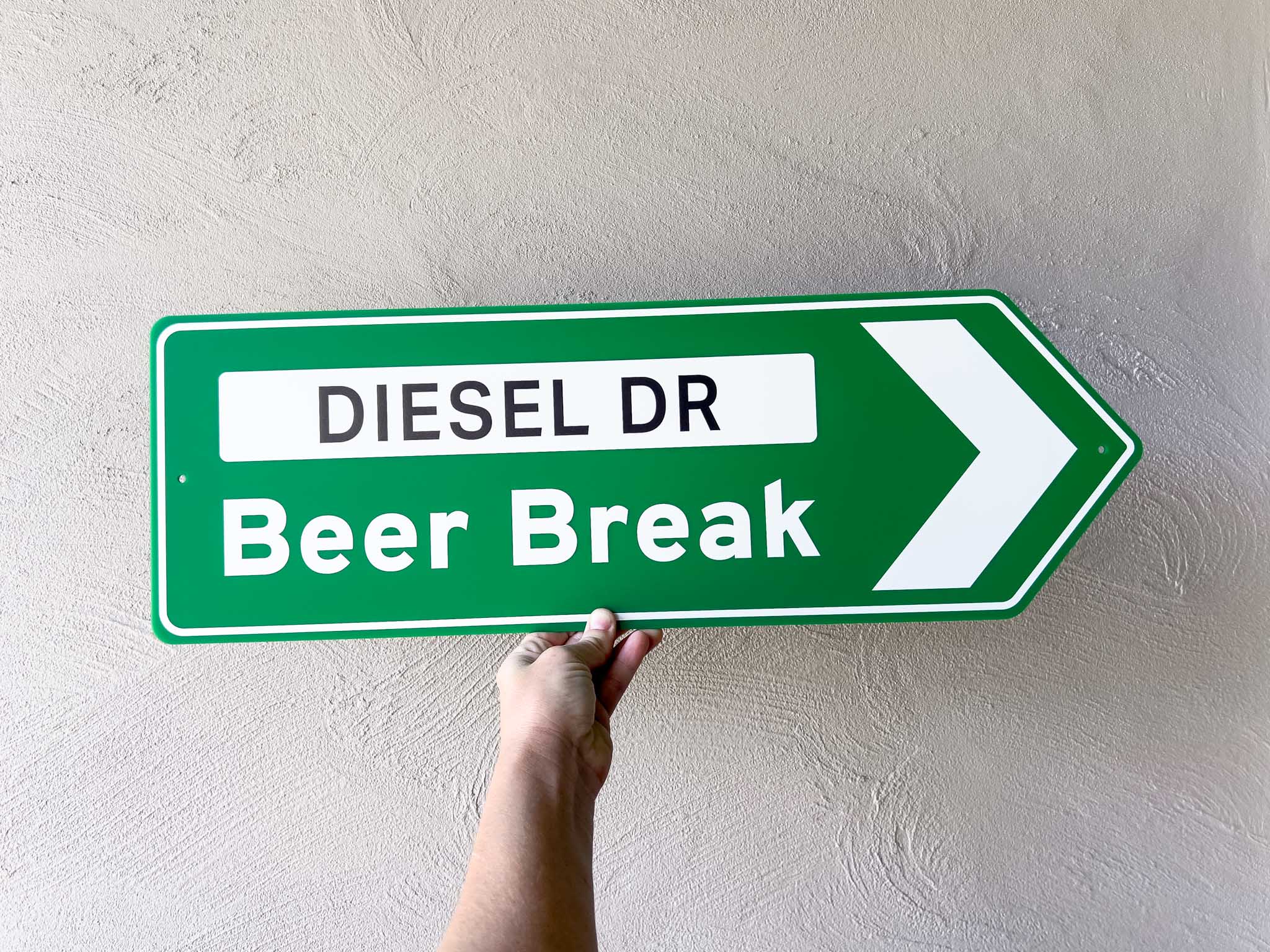 Classic retro green highway sign with 'DIESEL DR Beer Break' text against a plain background
