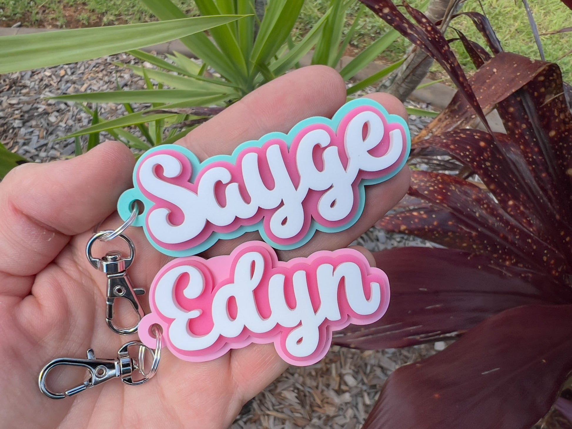 Tropical bubbly style custom keychains that read 'Sayge' in mint and pink and 'Edyn' in pink and white.