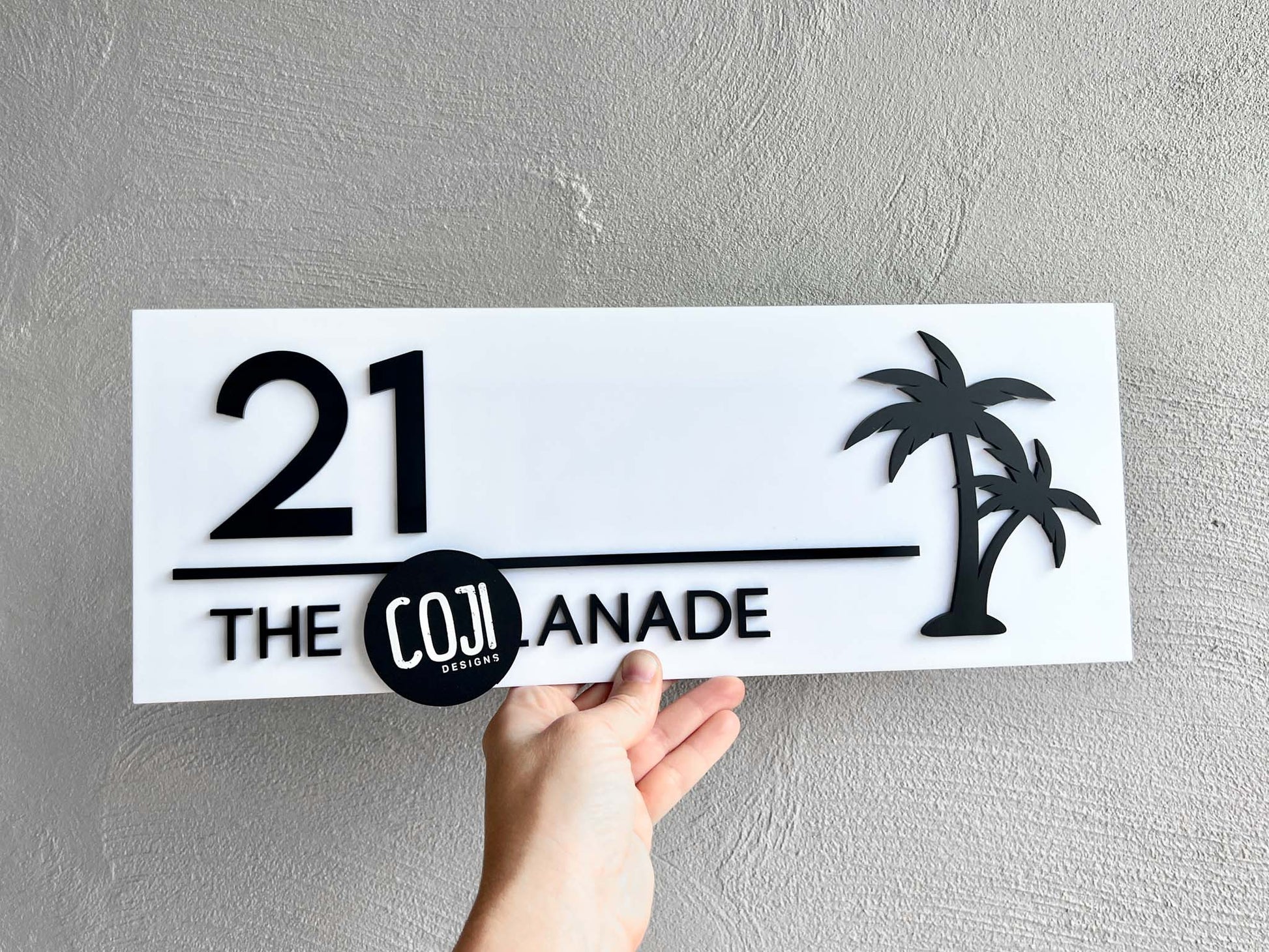 Beautiful black and white acrylic house sign with a black palm tree and text that has the number '21'.