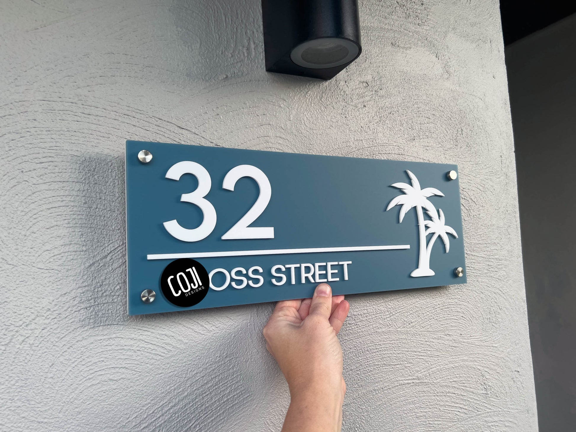 Dusty ocean blue and white tropical palm tree street address sign with the numbers '32'.
