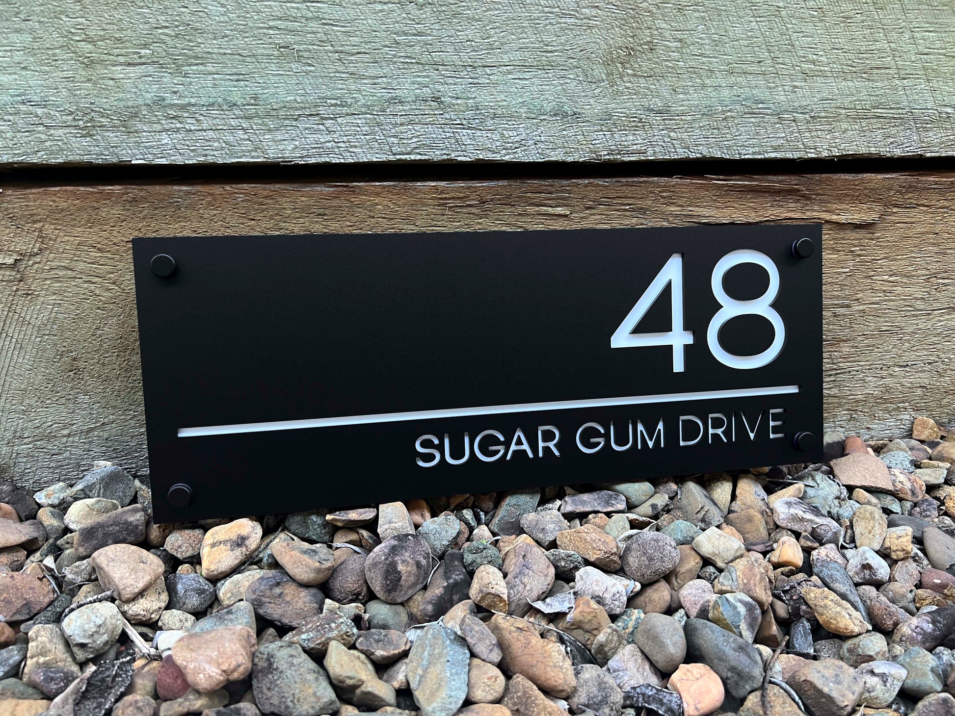 Handmade custom modern acrylic house sign in black and white with the number '48'.