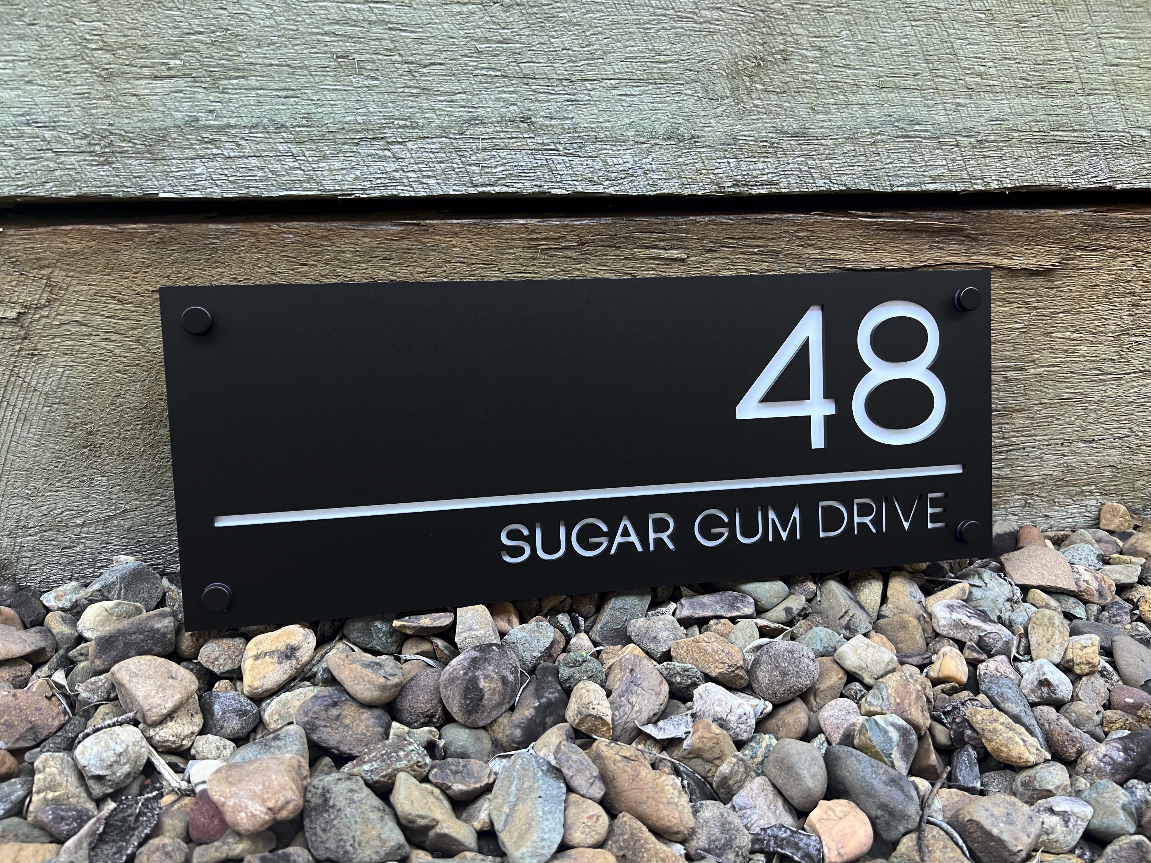 Handmade custom modern acrylic house sign in black and white with the number '48'.