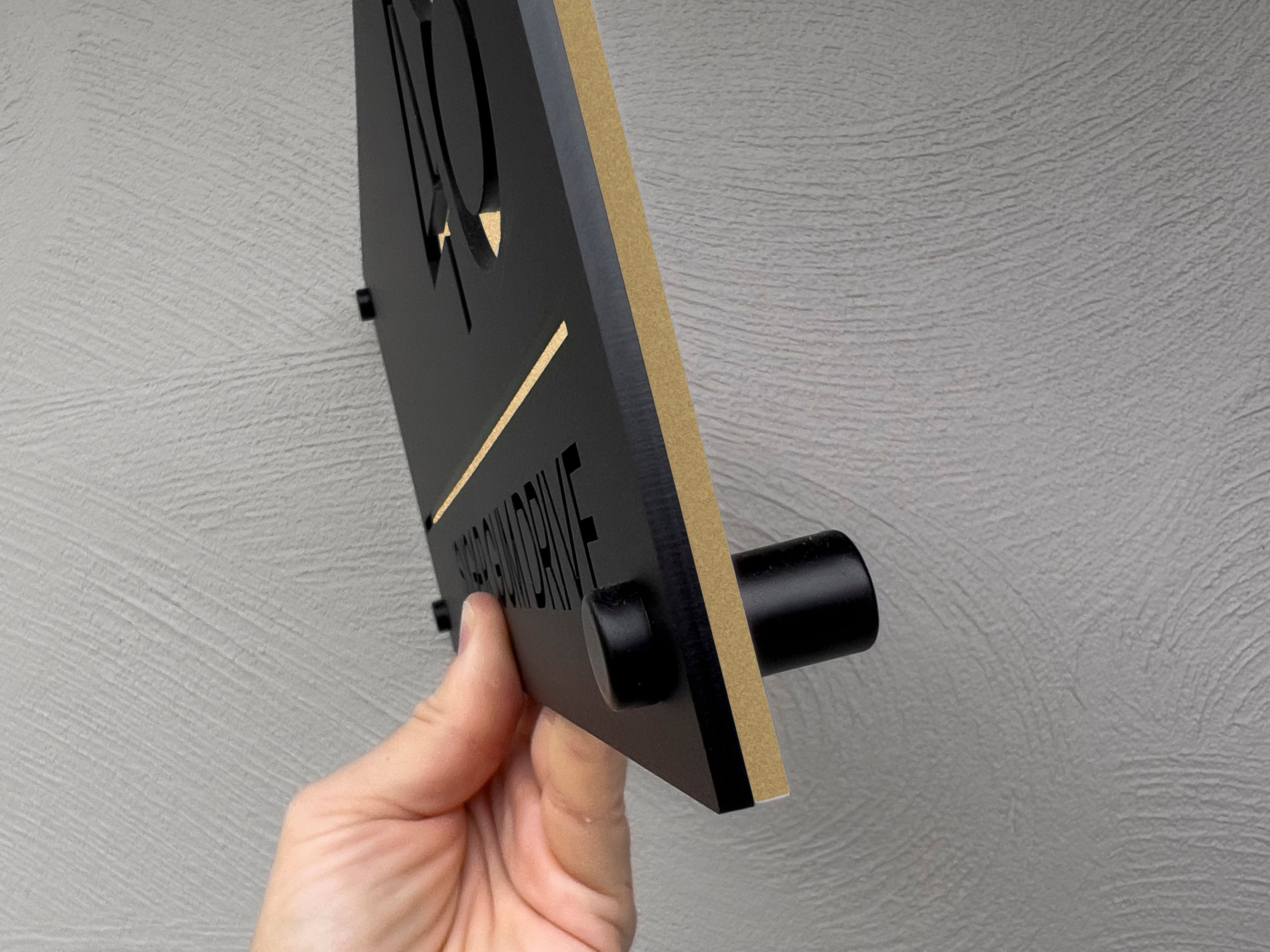 Hand hold the Bali modern address sign with a side view.