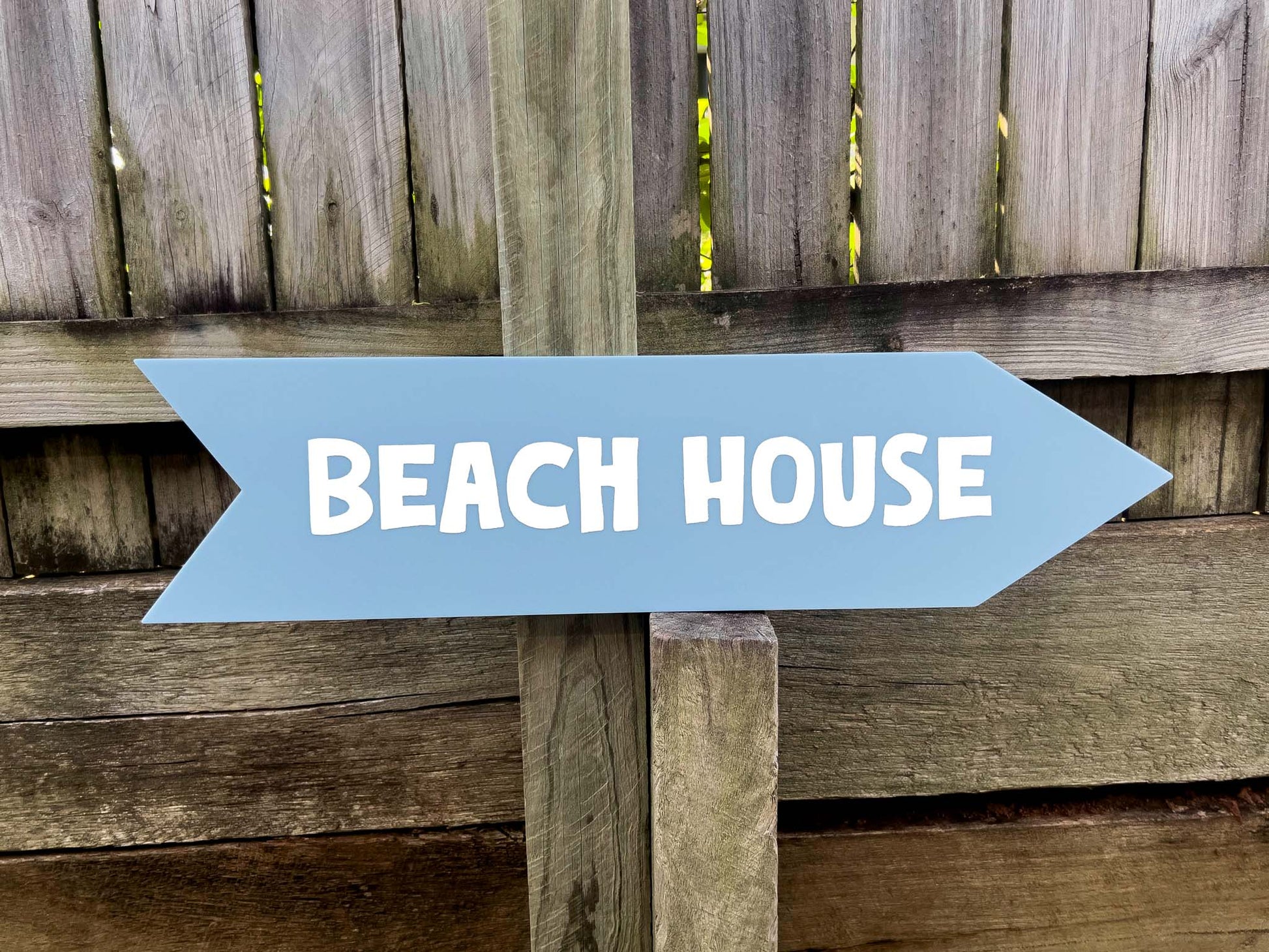 A light dusty blue colour arrow with the text 'Beach House' printed on it pointing to the right.