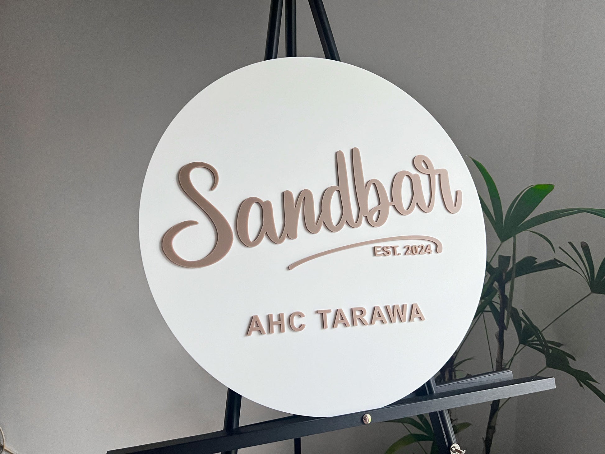 Round personalised sign with 'Sandbar' and 'AHC Tarawa' text on a stand against a neutral background
