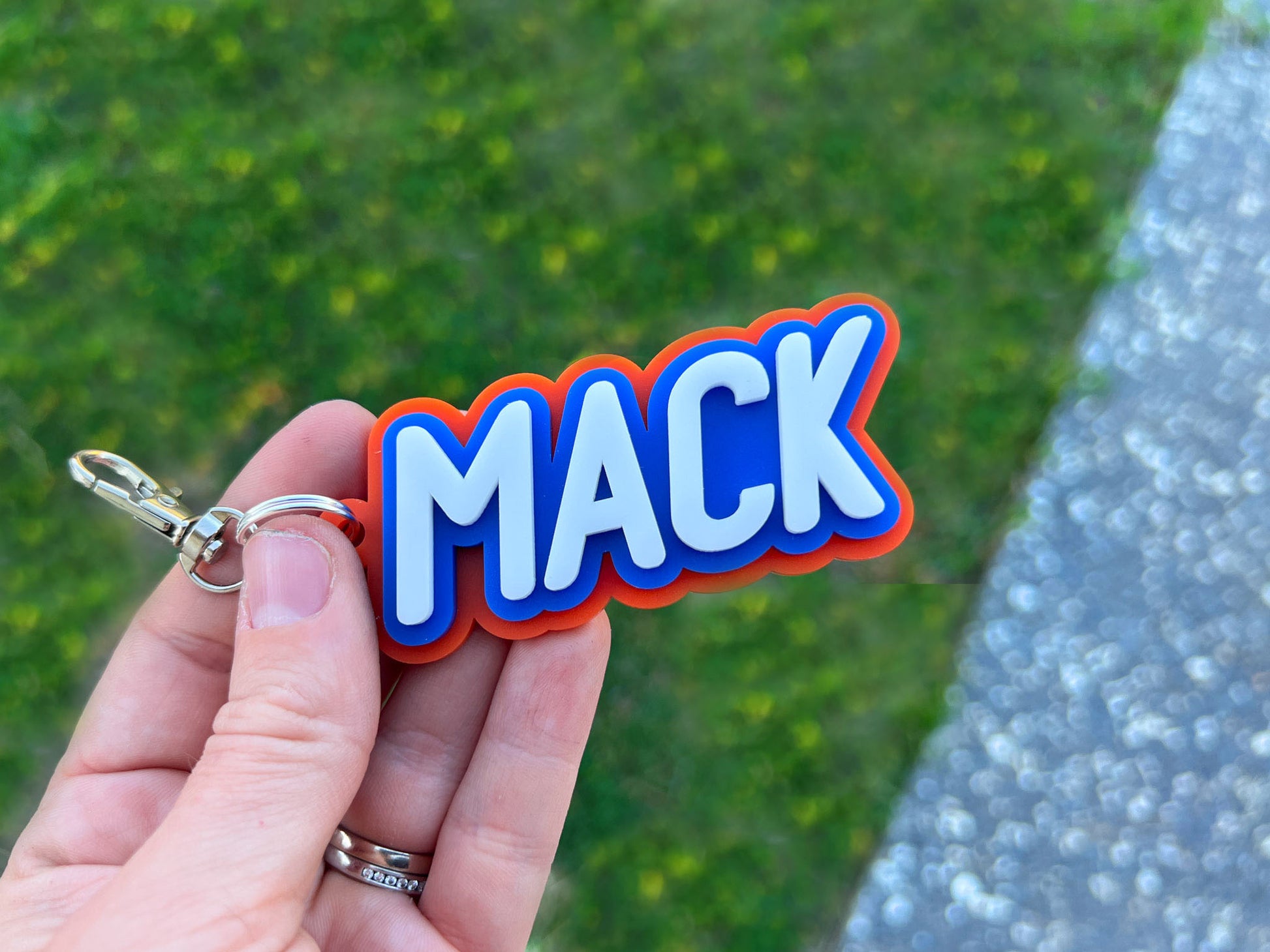 Triple layer 3D acrylic keychain with bold typography that says 'MACK'