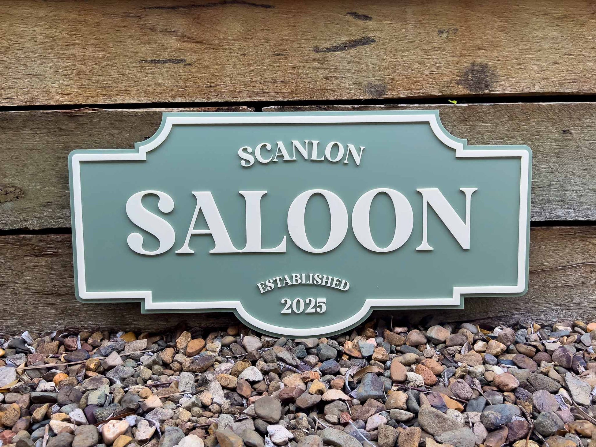 Green and beige vintage style sign that says 'Scanlon Saloon'.