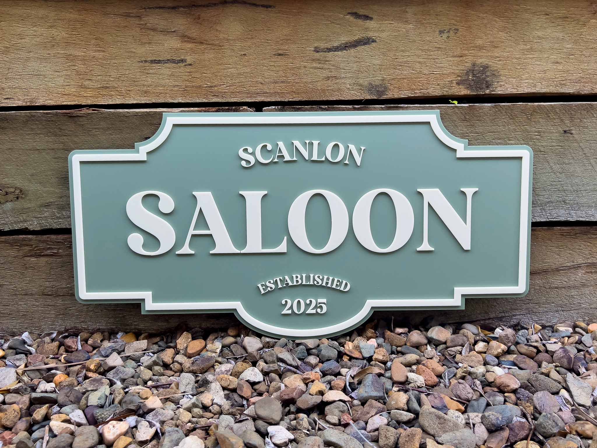 Green and beige vintage style sign that says 'Scanlon Saloon'.