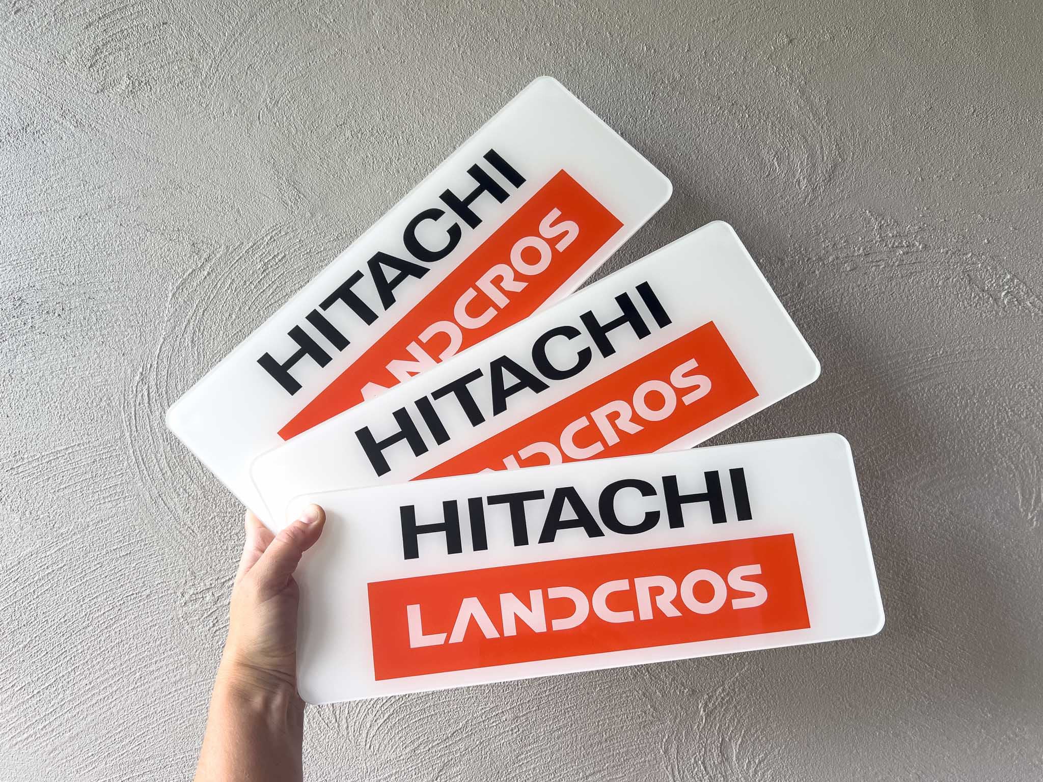 Three Hitachi Landcros glossy logo plates | Coji Designs