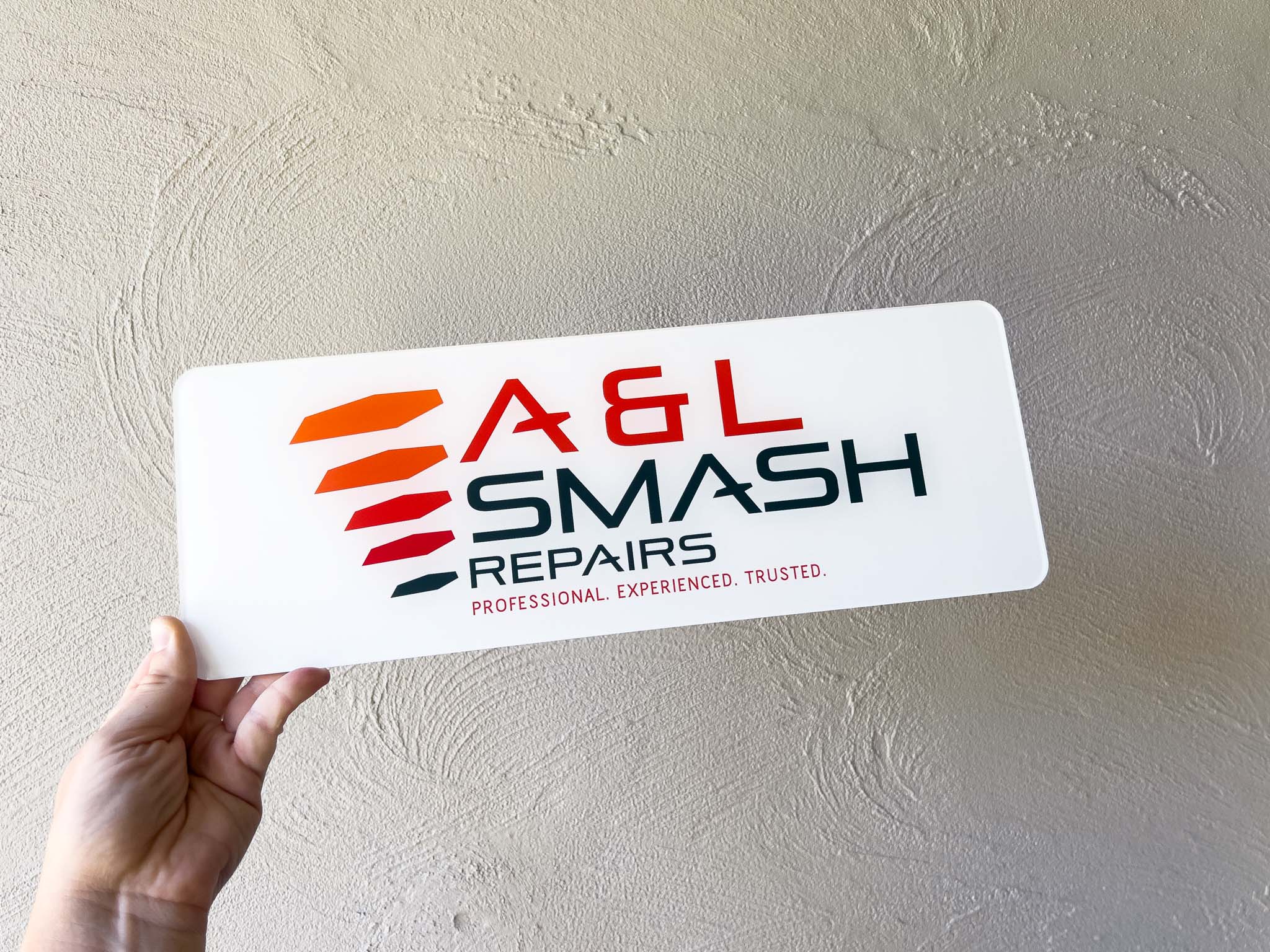 Custom printe white and red logo plate for a Smash Repairer