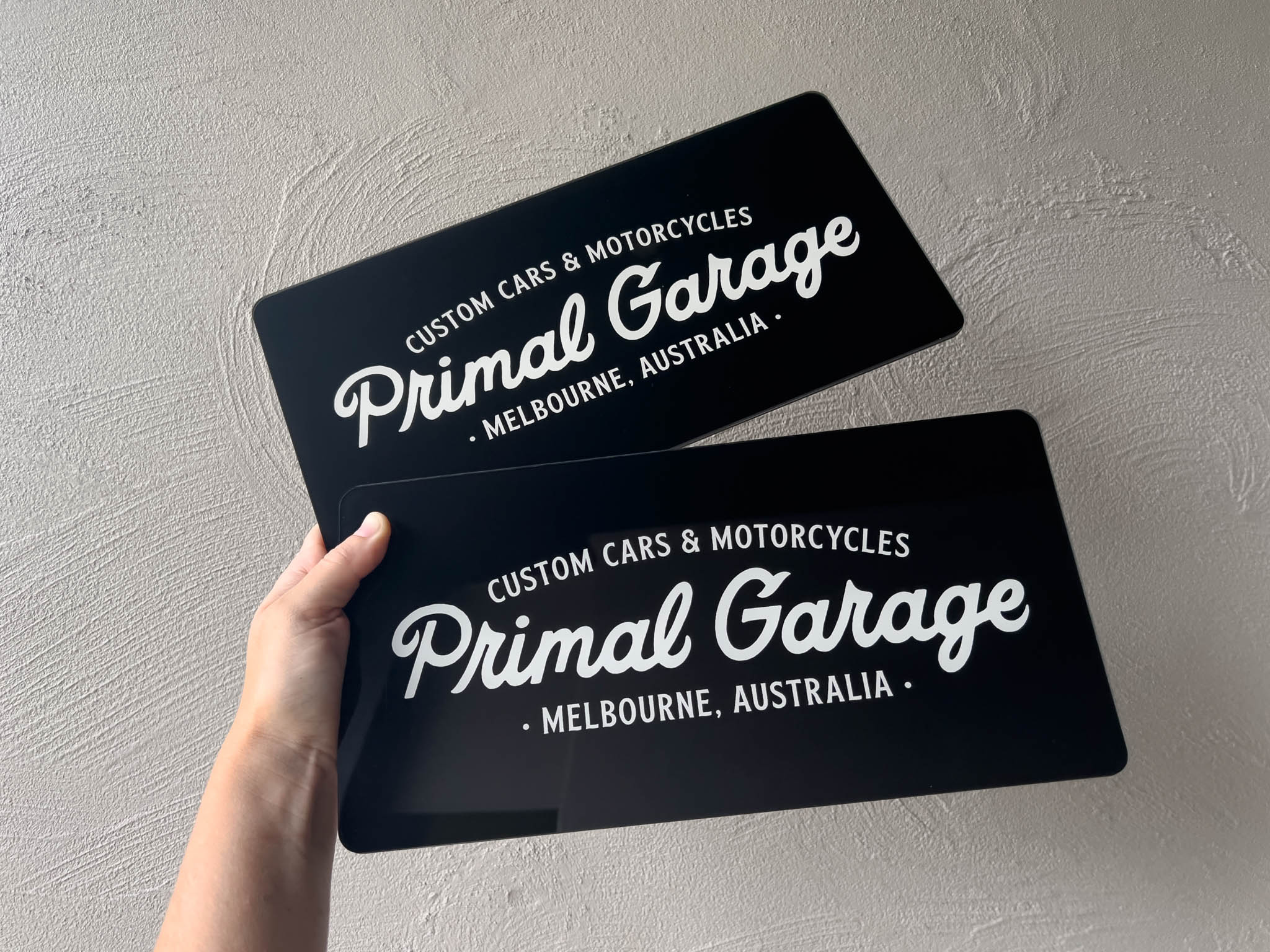 Two black and white custom printed logo cover plates with a clear gloss finish