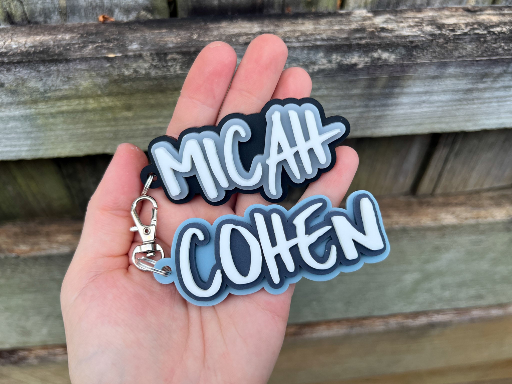 Big wave surf style custom 3D acrylic name tags that read 'Micah' & 'Cohen' in shades of blue, white and black.