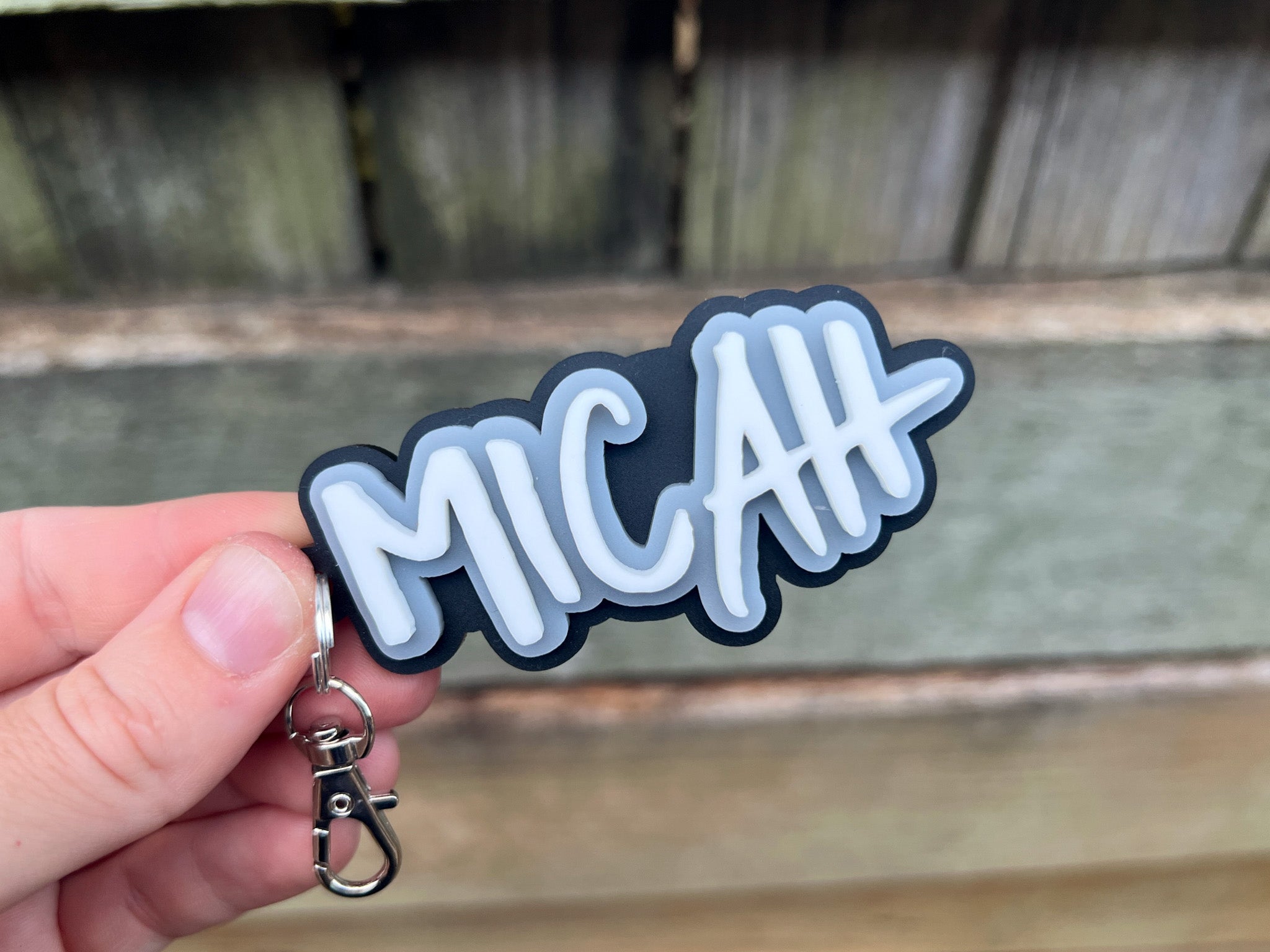 Retro vibe, surf-style accessories custom acrylic keychain in black, grey and white that says 'Micah'.
