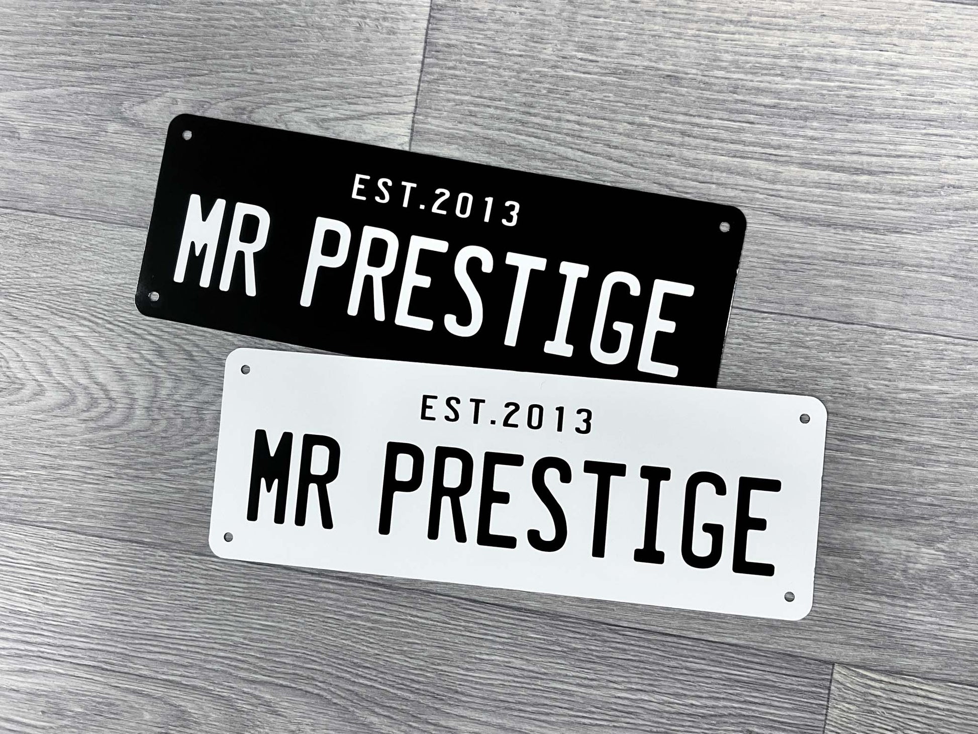 Two 'MR PRESTIGE' number plate style signs in white and black