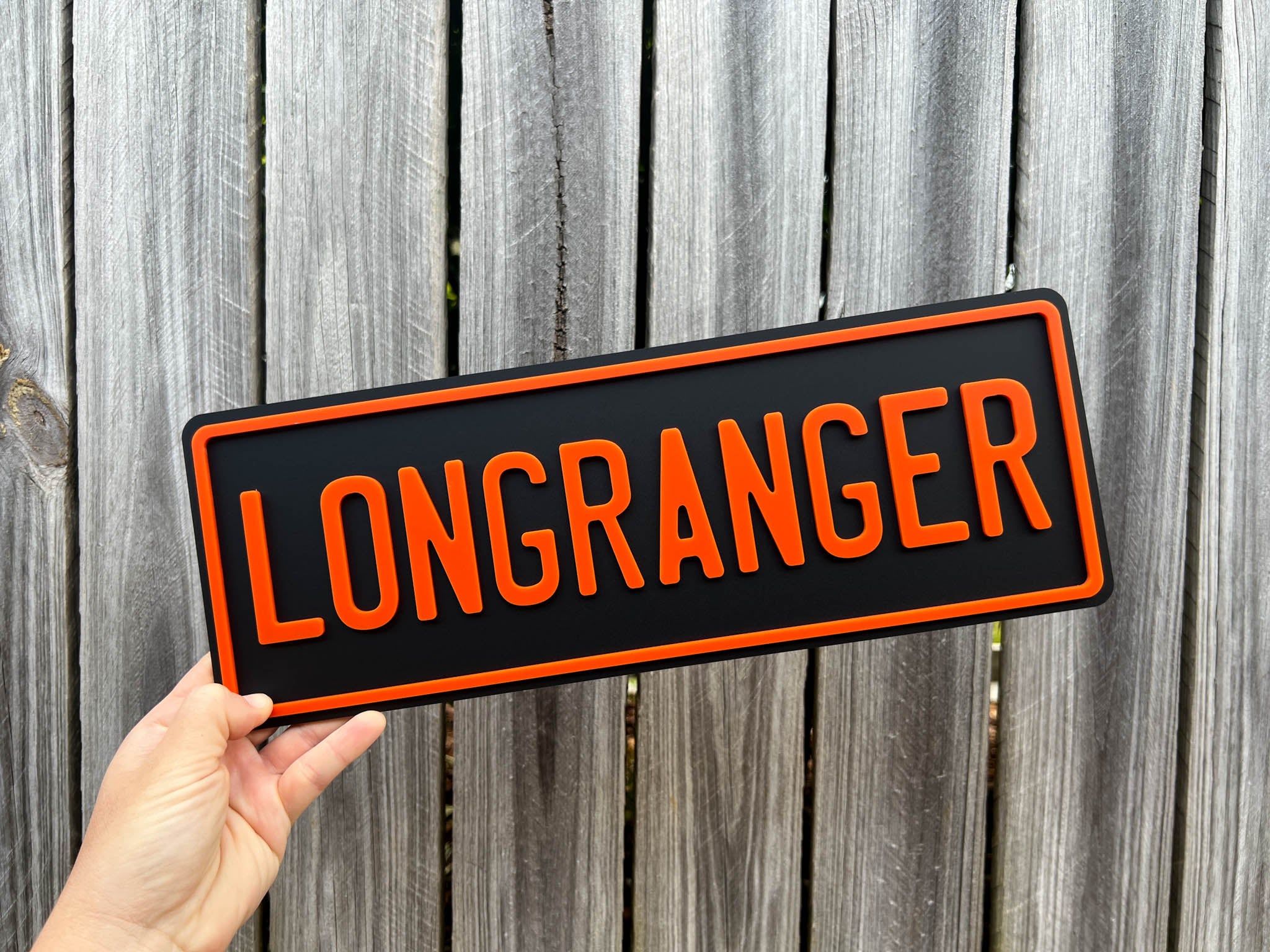 A black plate with the word 'LONGRANGER' in orange 3D acrylic lettering