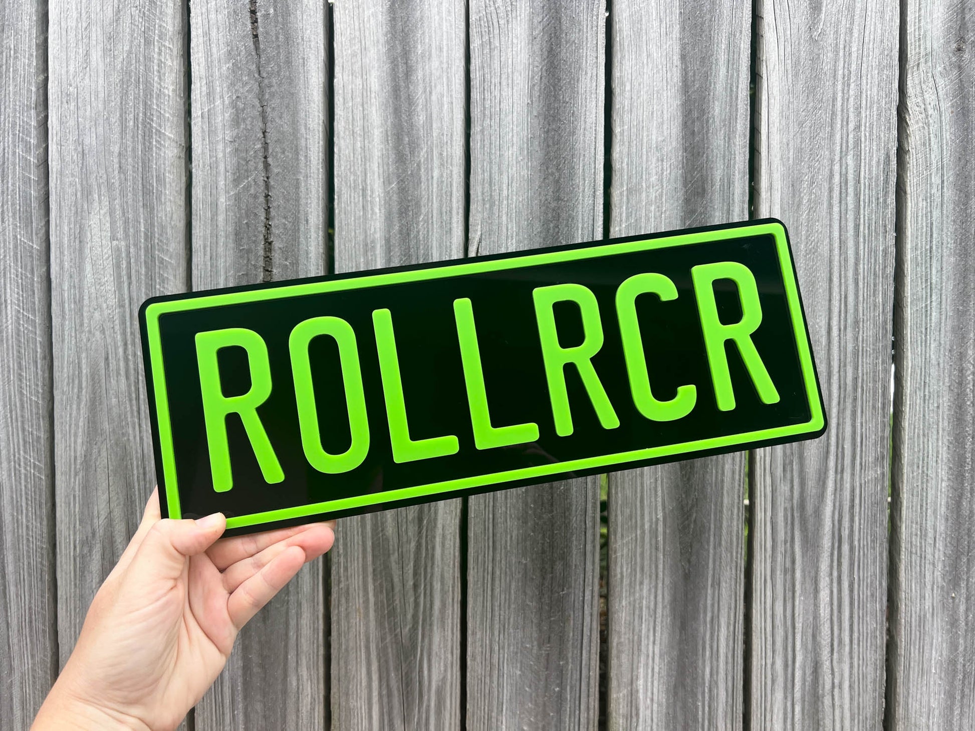 A custom made 3D acrylic plate in black and lime green that reads 'ROLLRCR'