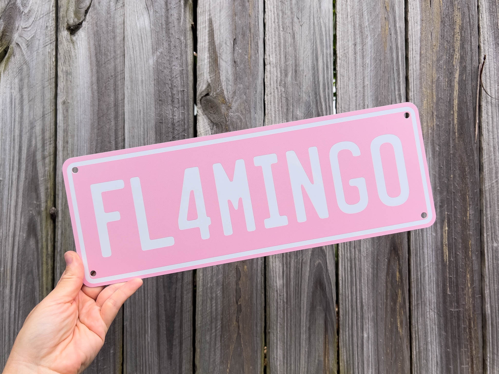 Light pink and white number plate style sign that says 'FL4MINGO'.