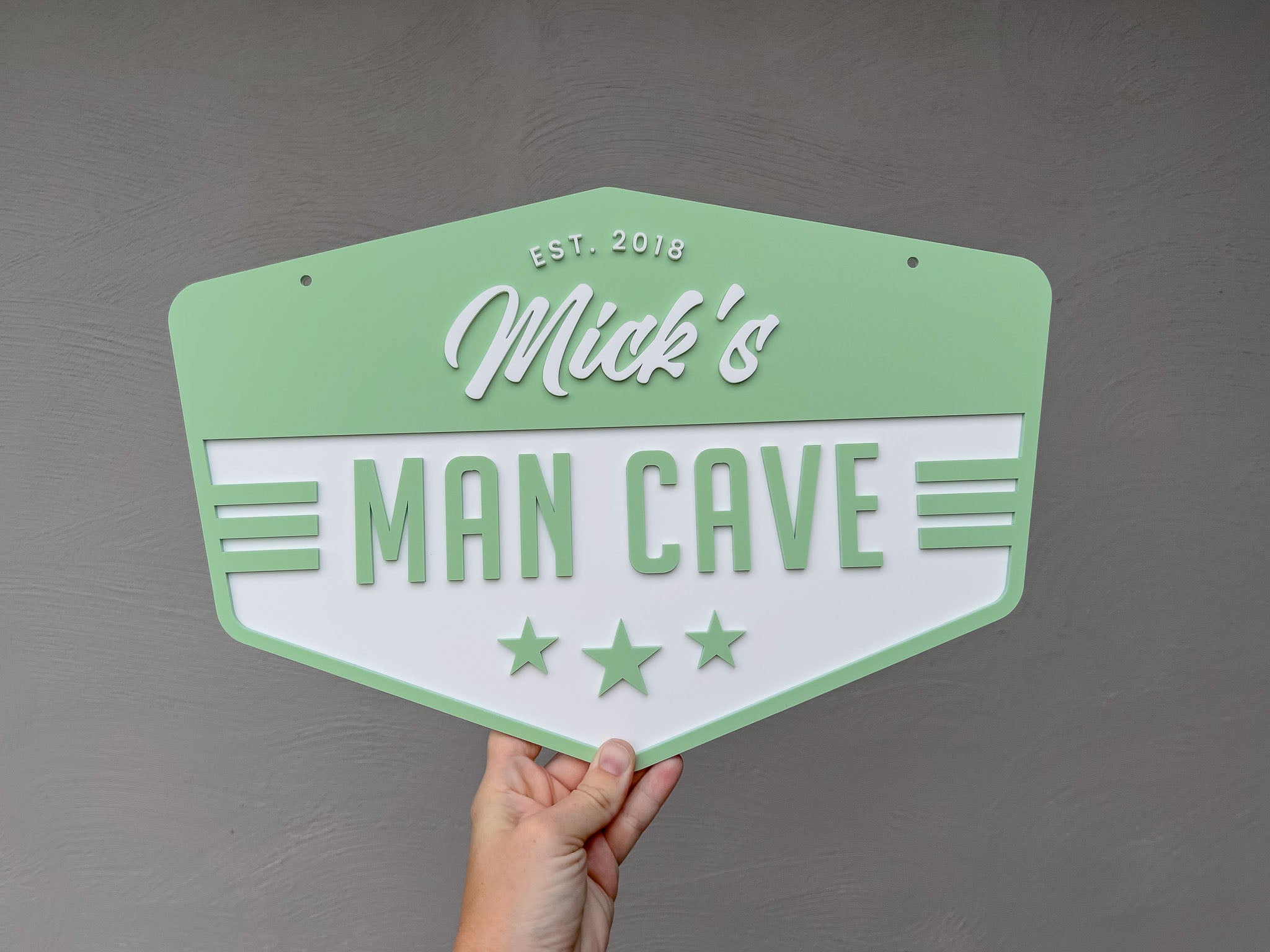 Retro vintage badge sign that has been custom made from layers of acrylic that says 'Mick's Man Cave' in a vintage green colour.