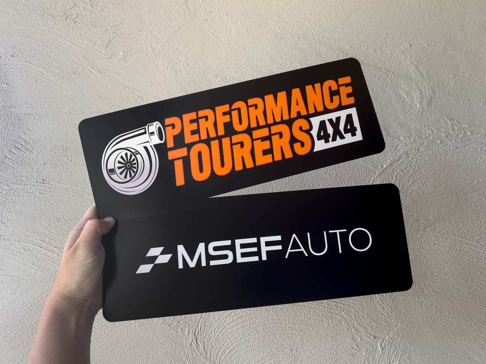 Two personalised UV printed flexible logo plates in black, white and orange.