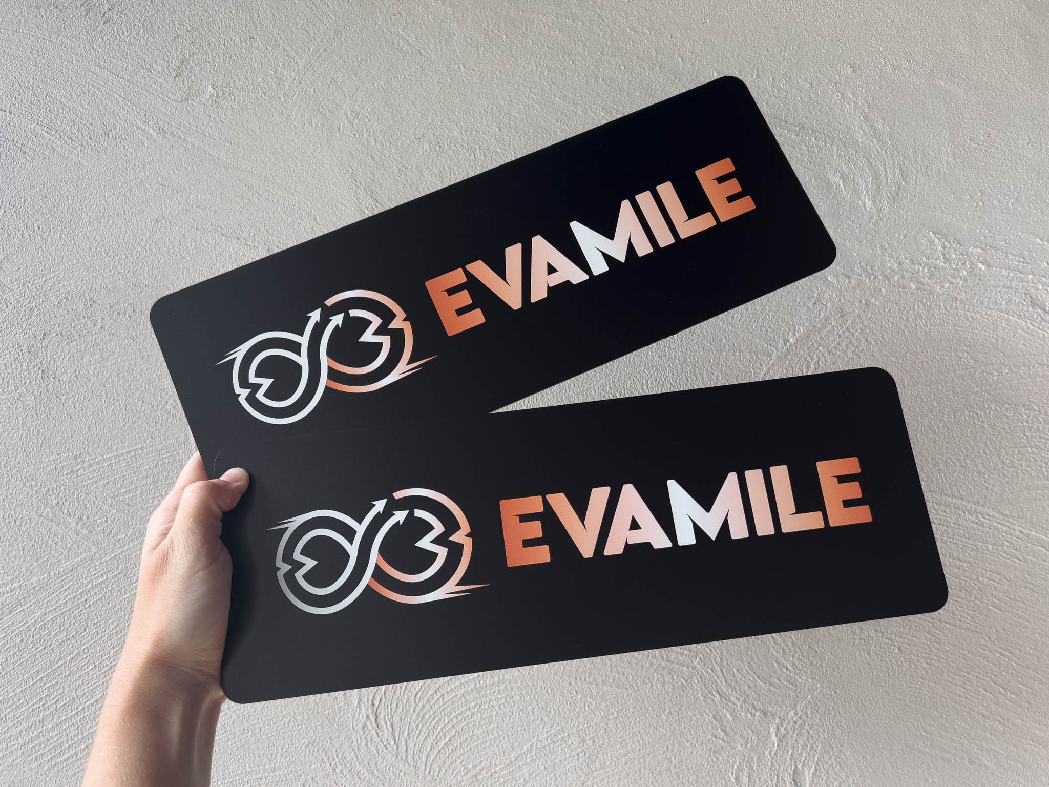 UV printed flexible logo prints printed with 'Evamile' in black, white and orange.