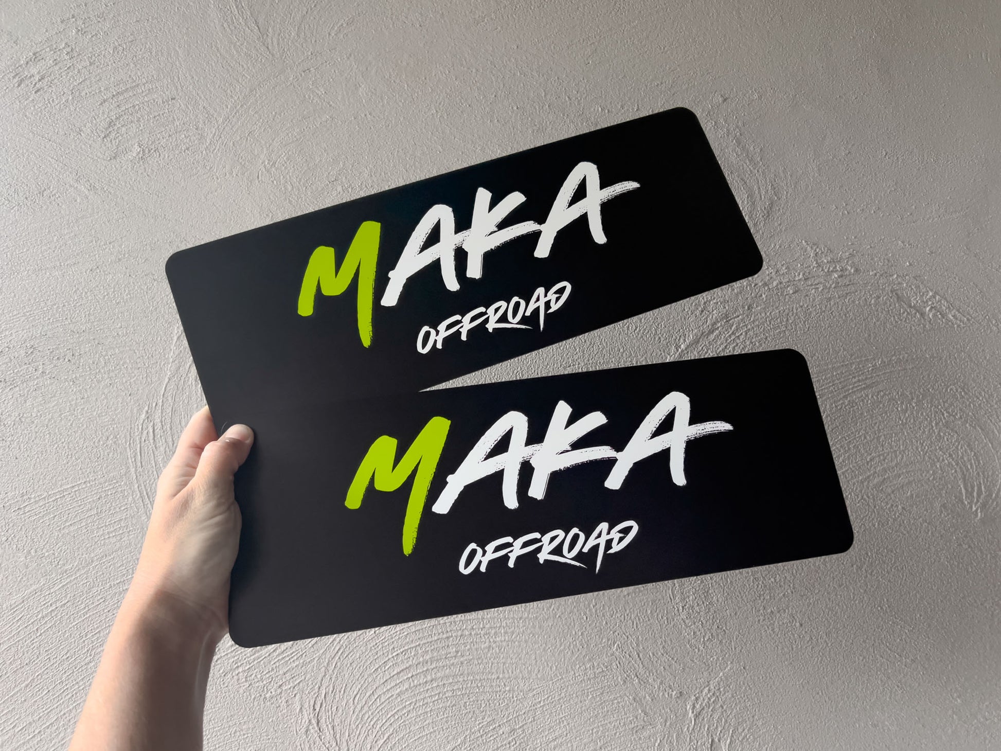 Two flexible black and white logo plates with the brand name 'Maka Offroad' on them.