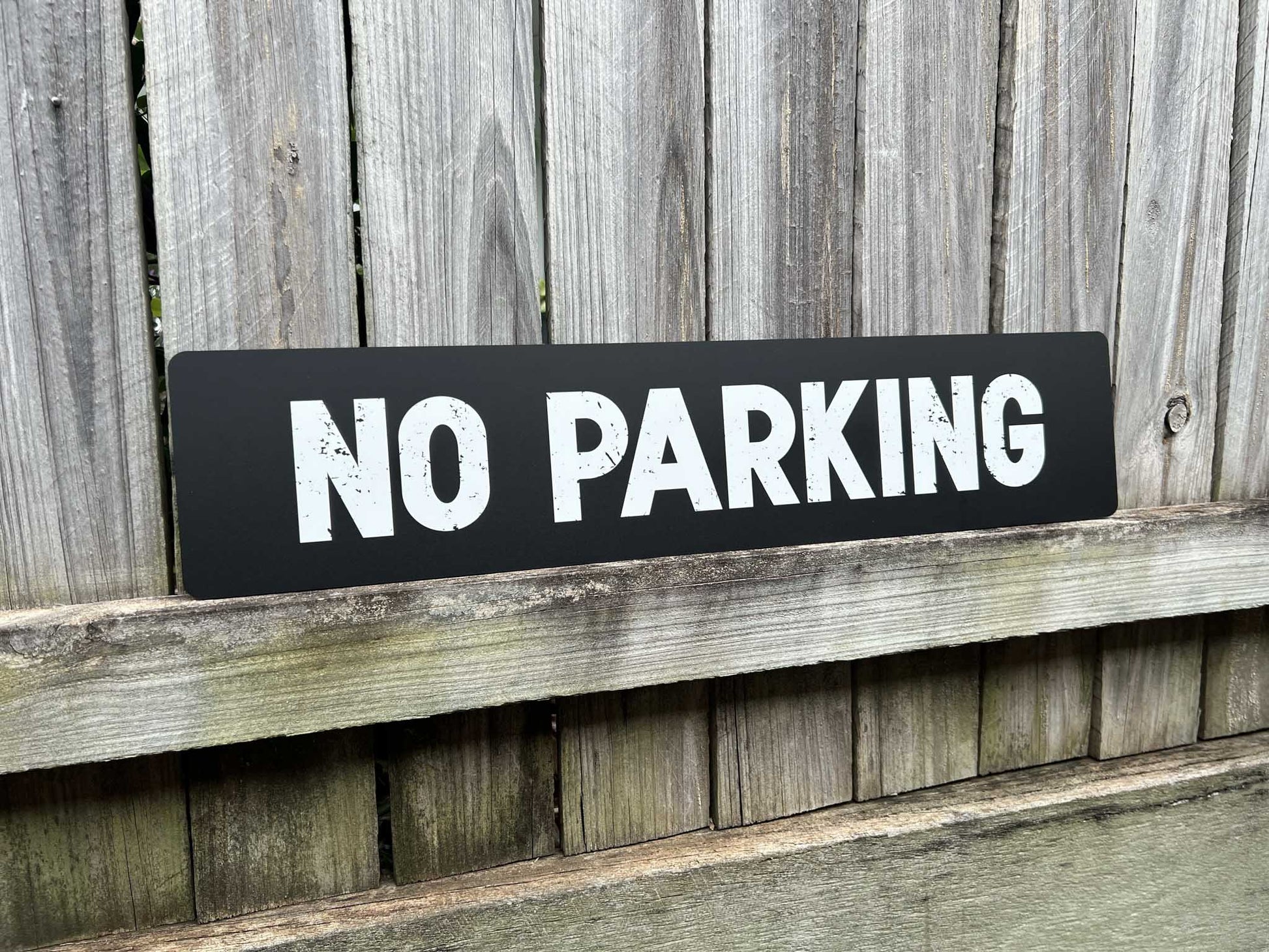 Custom UV printed rough textured text sign in black and white that reads 'NO PARKING'.