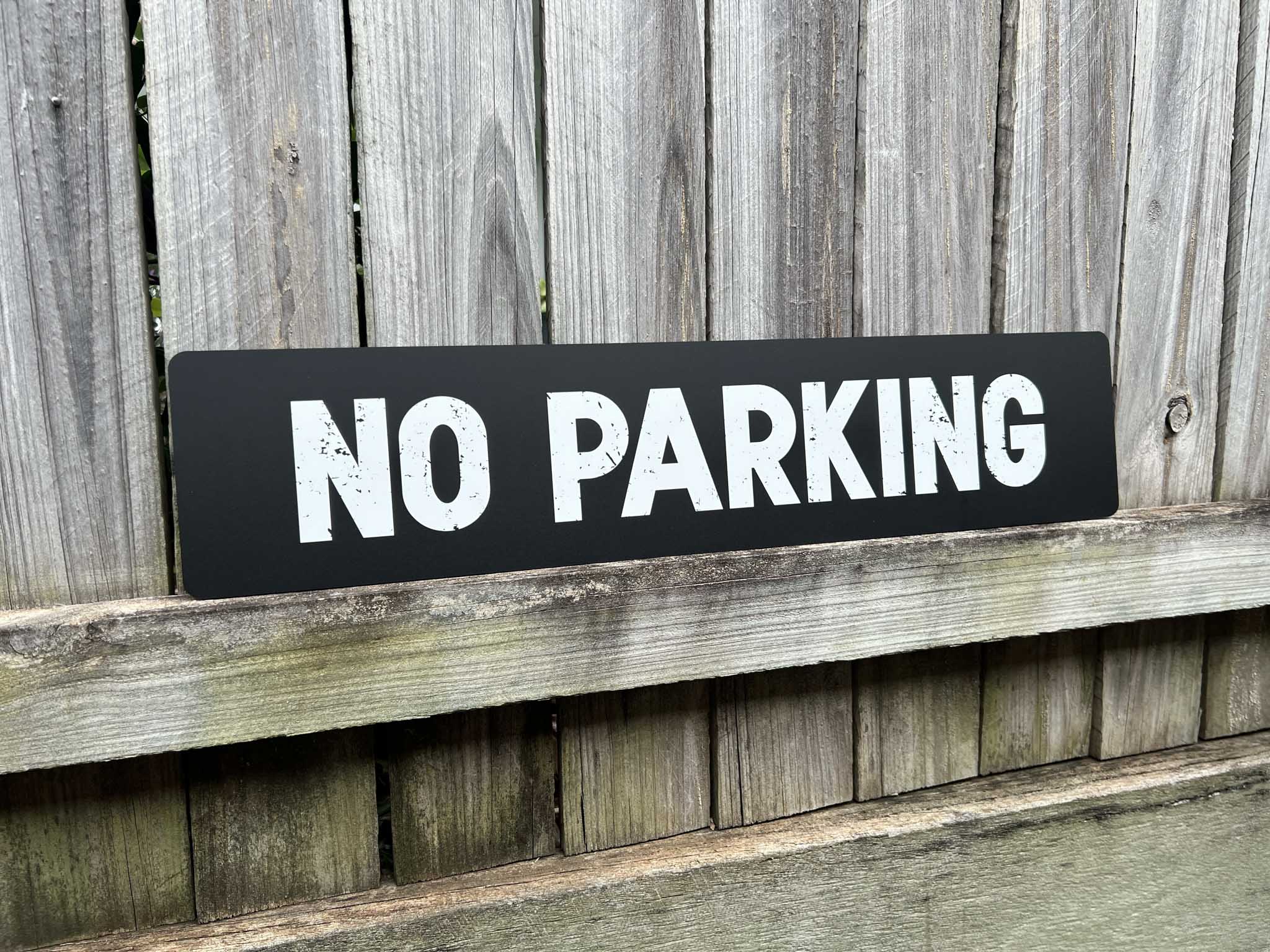 Custom UV printed rough textured text sign in black and white that reads 'NO PARKING'.
