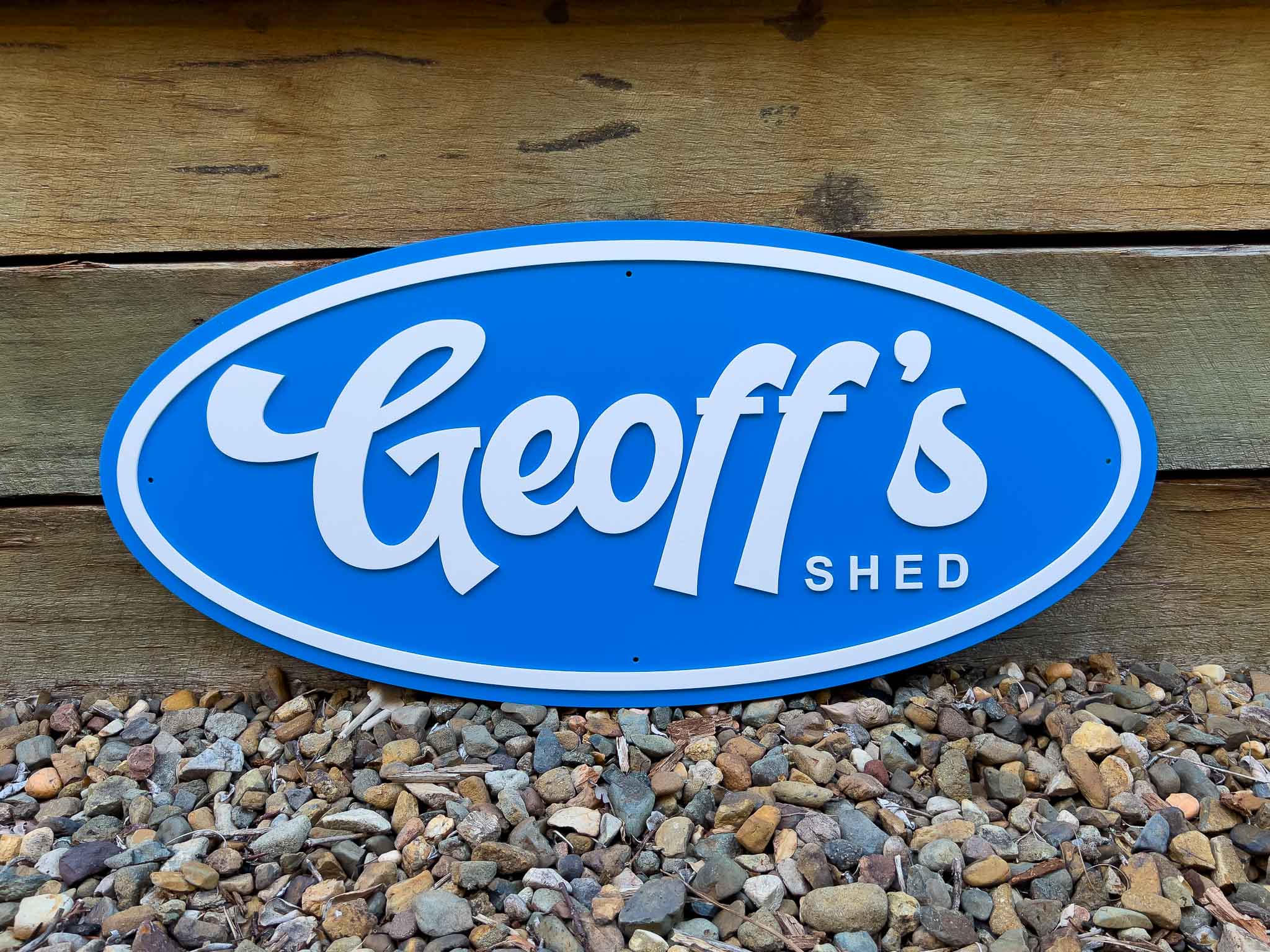 Classic custom made oval badge style sign that says 'Geoff's Shed' in a sky blue and white colour.