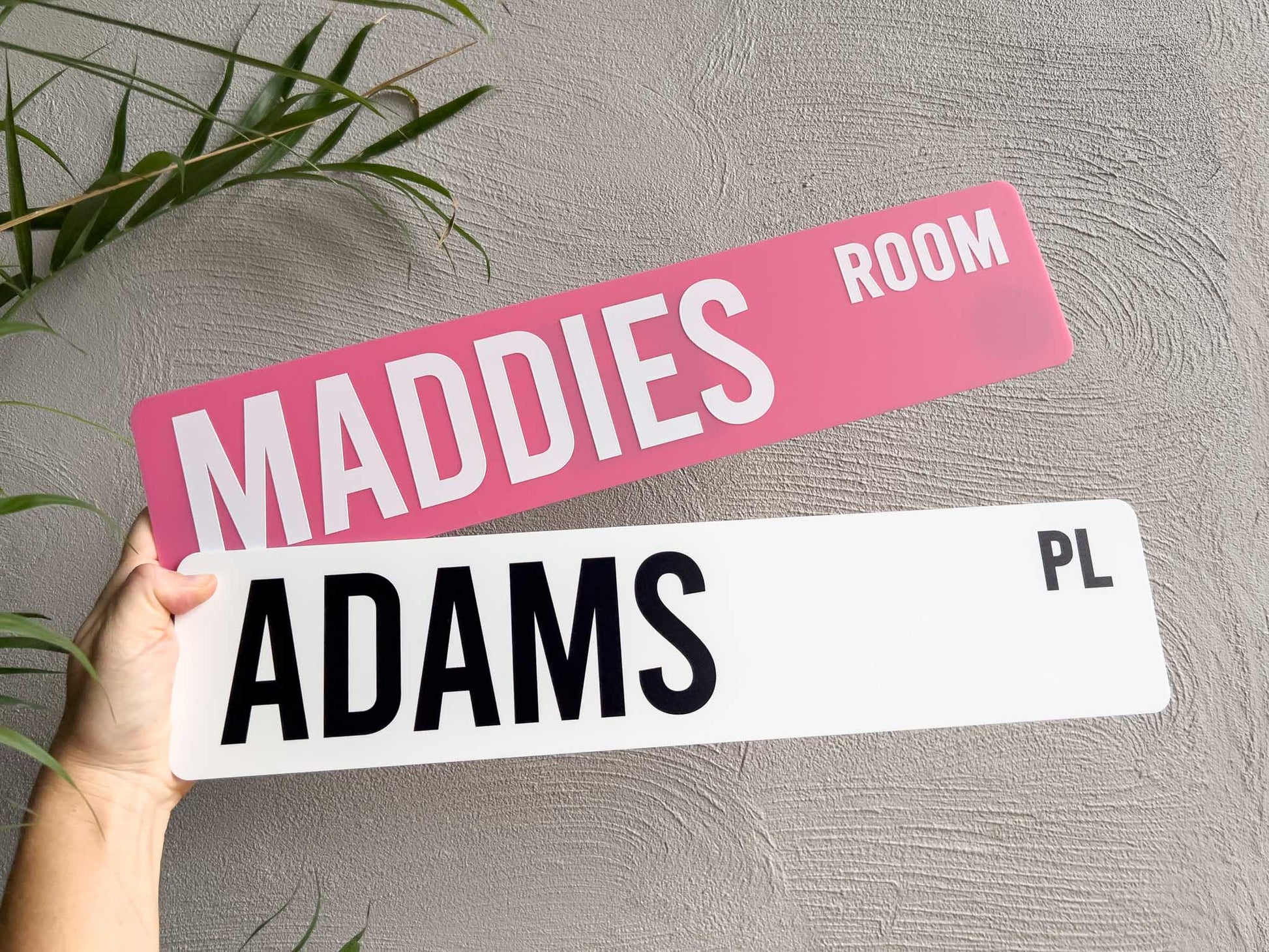 Classic customisable acrylic street signs in pink and white that read 'MADDIES ROOM' & 'ADAMS PL'.