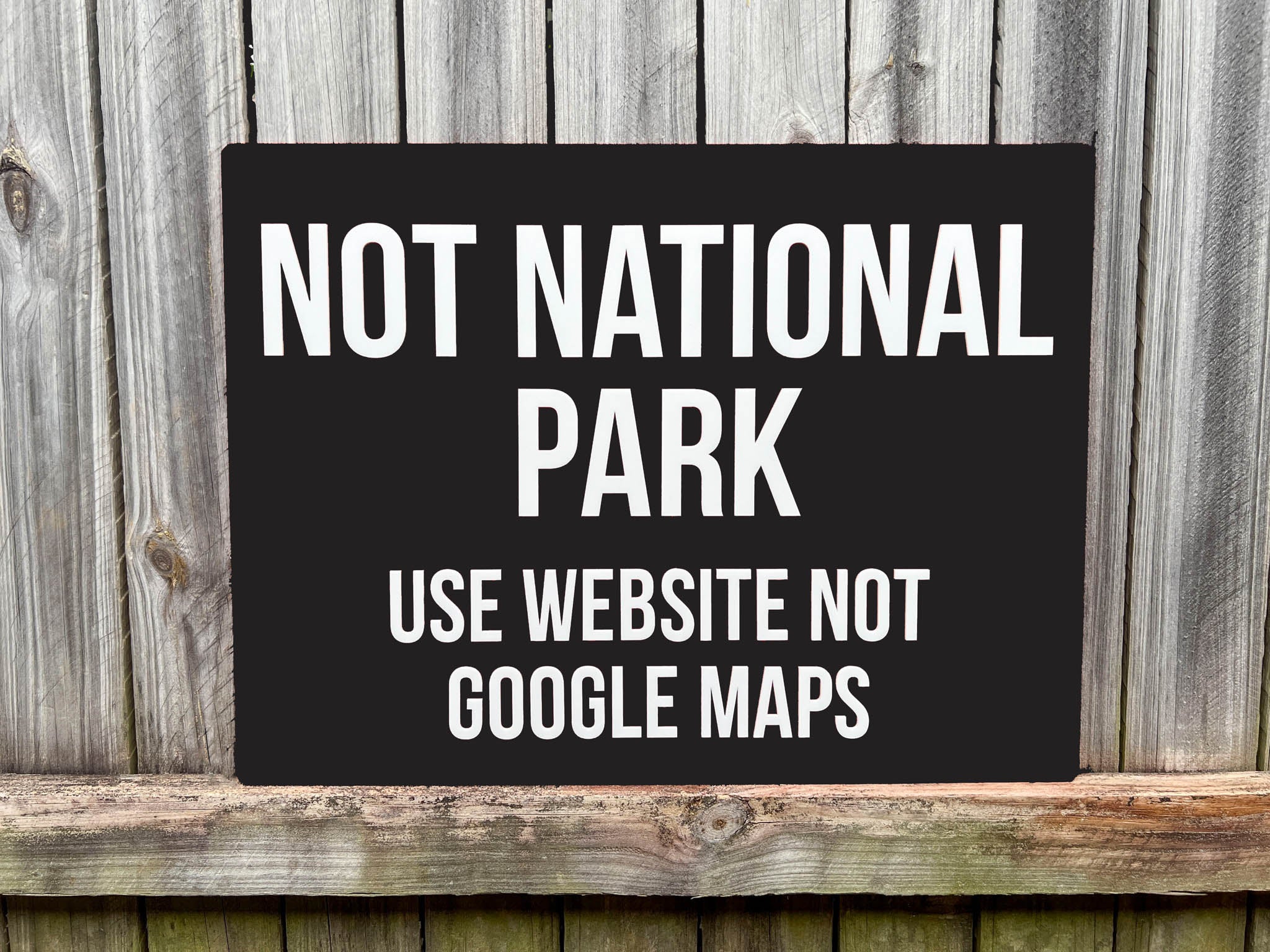 Custom 3D Acrylic black sign with white text on a wooden background