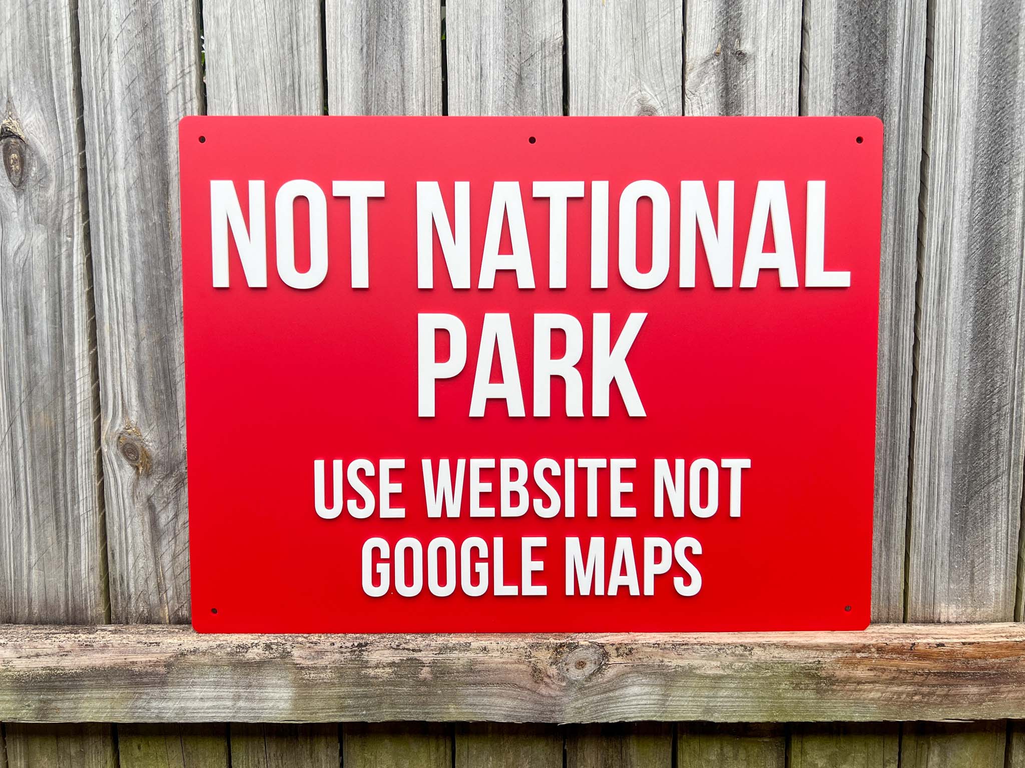 Red sign with white text on a wooden background