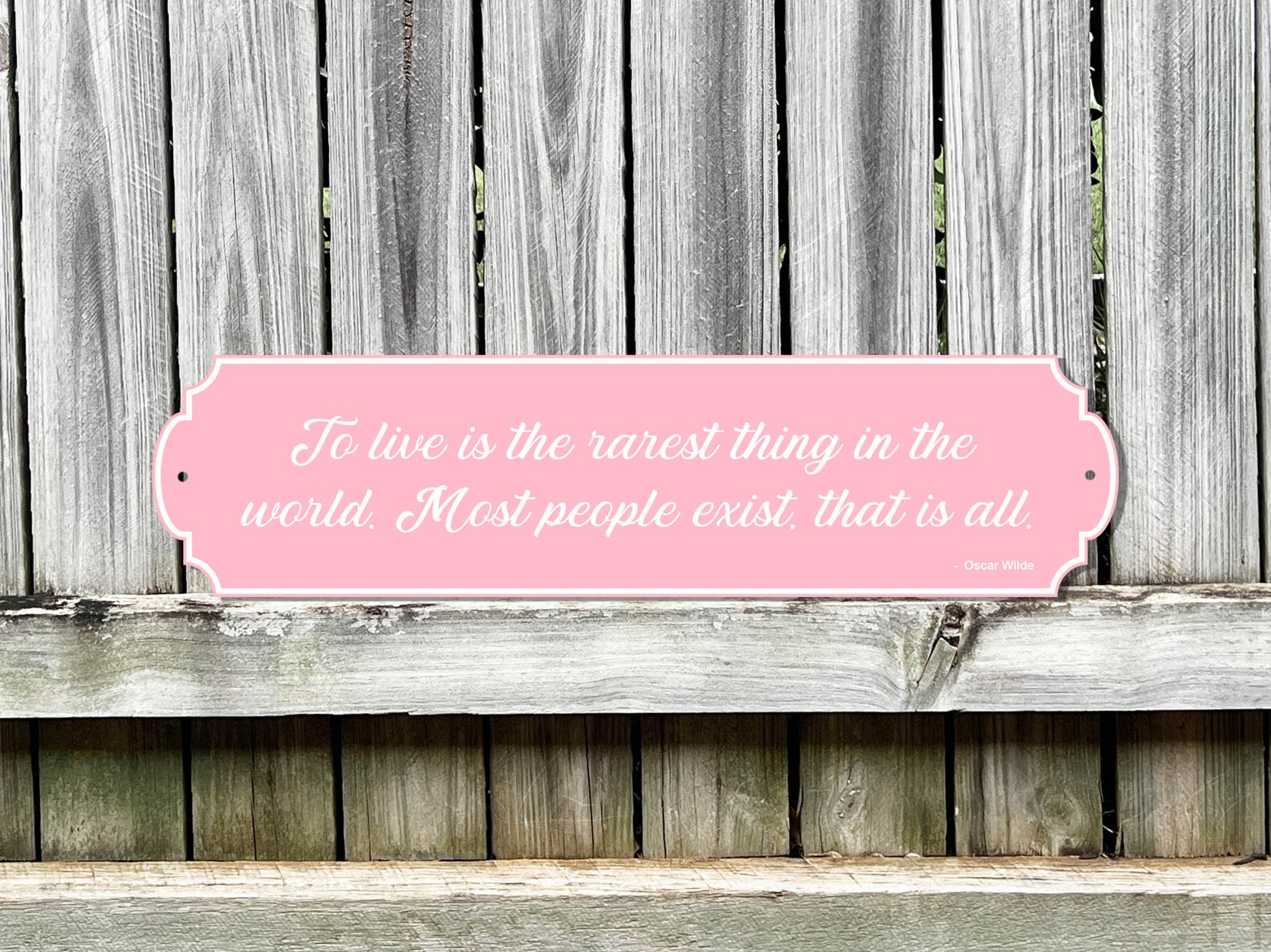 Custom quote sign in pink with white writing in an antique retro silhoutte shape and elegant cursive writing.