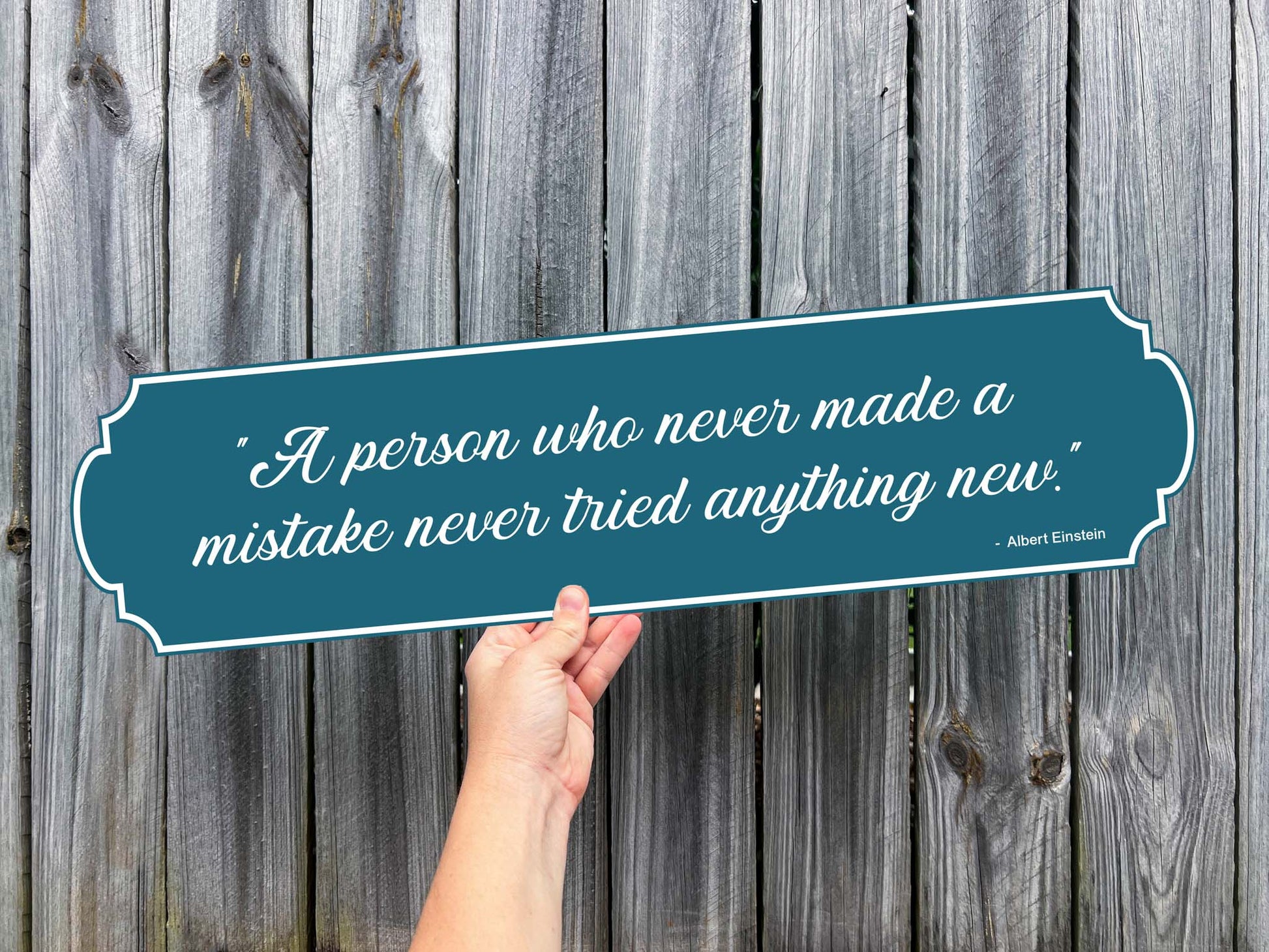 A UV printed custom text sign with a quote from Albert Einstein, speaking about trying new things on a vintage shaped dusty blue sign with white script writing. 