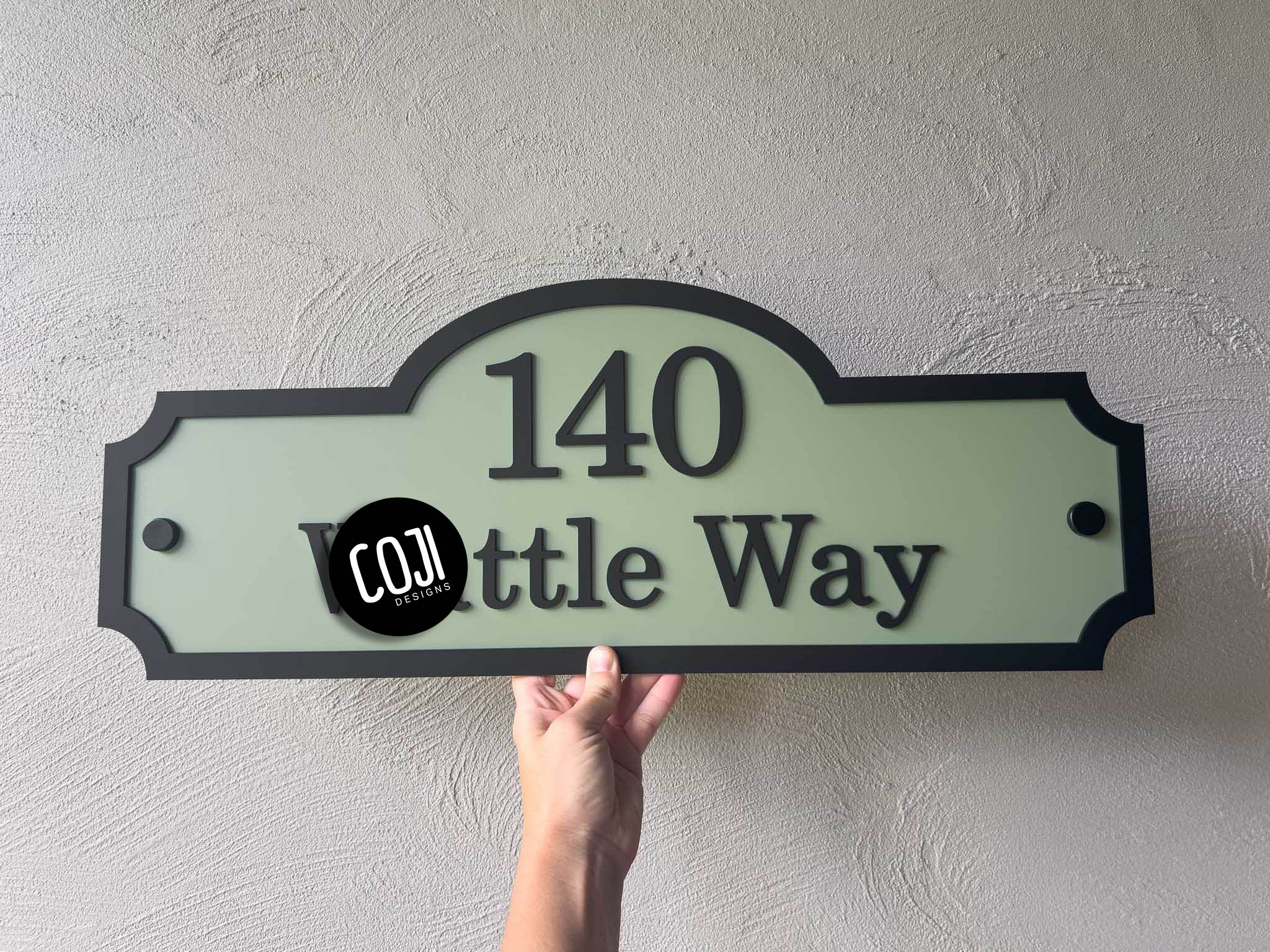A heritage green and black vintage style address sign with the number '140'.