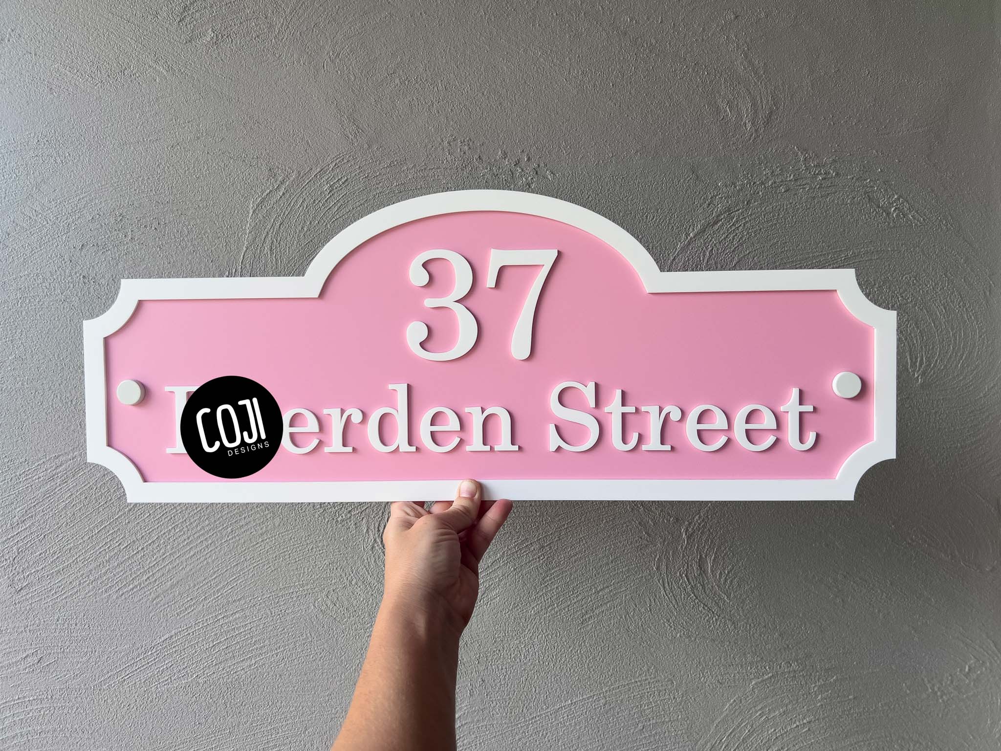 Classic heritage style address sign in light pink and white with the number '37' on it.