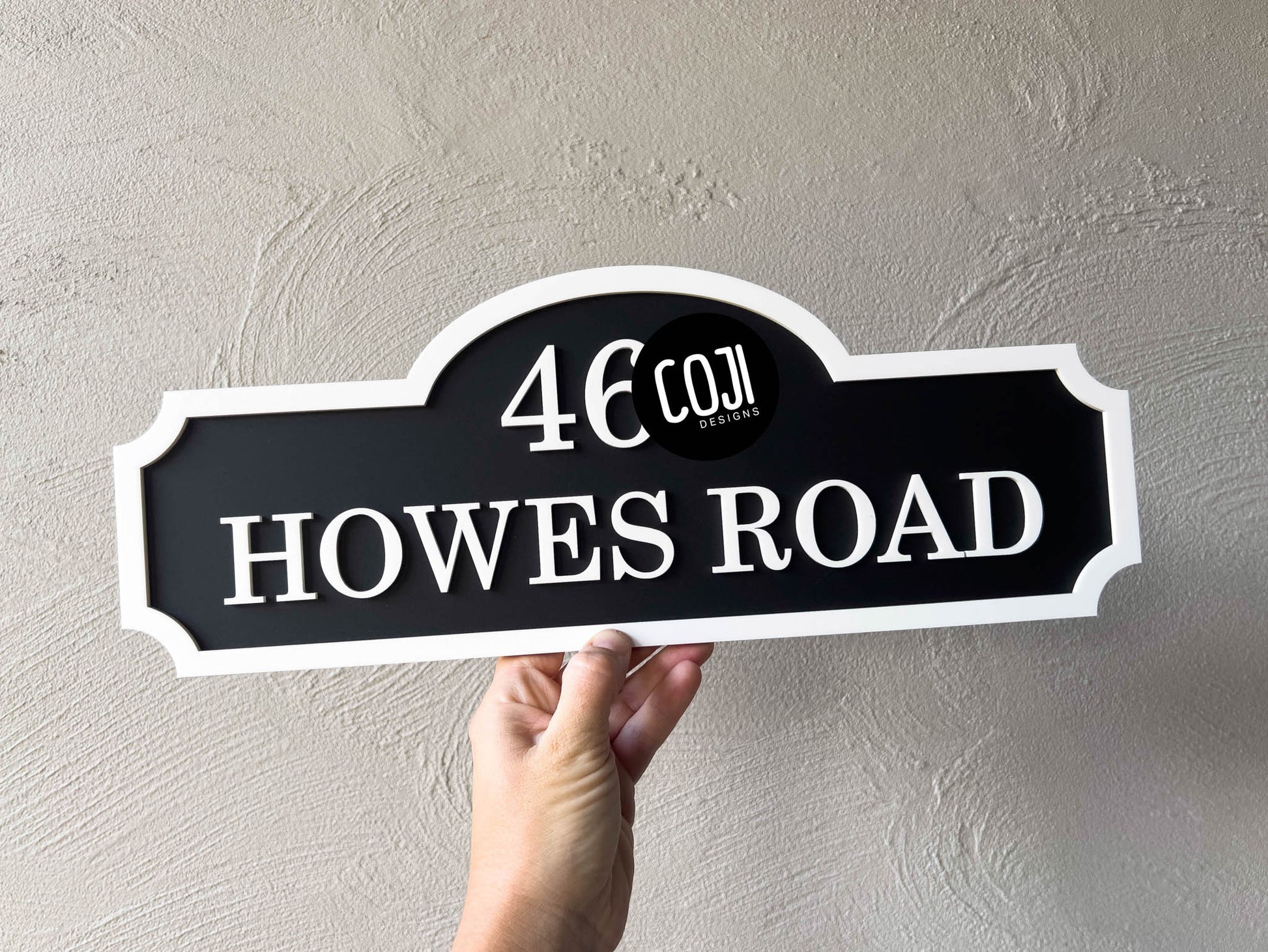 A 3D acrylic multi-layered address sign in black and white with 'HOWES ROAD'.