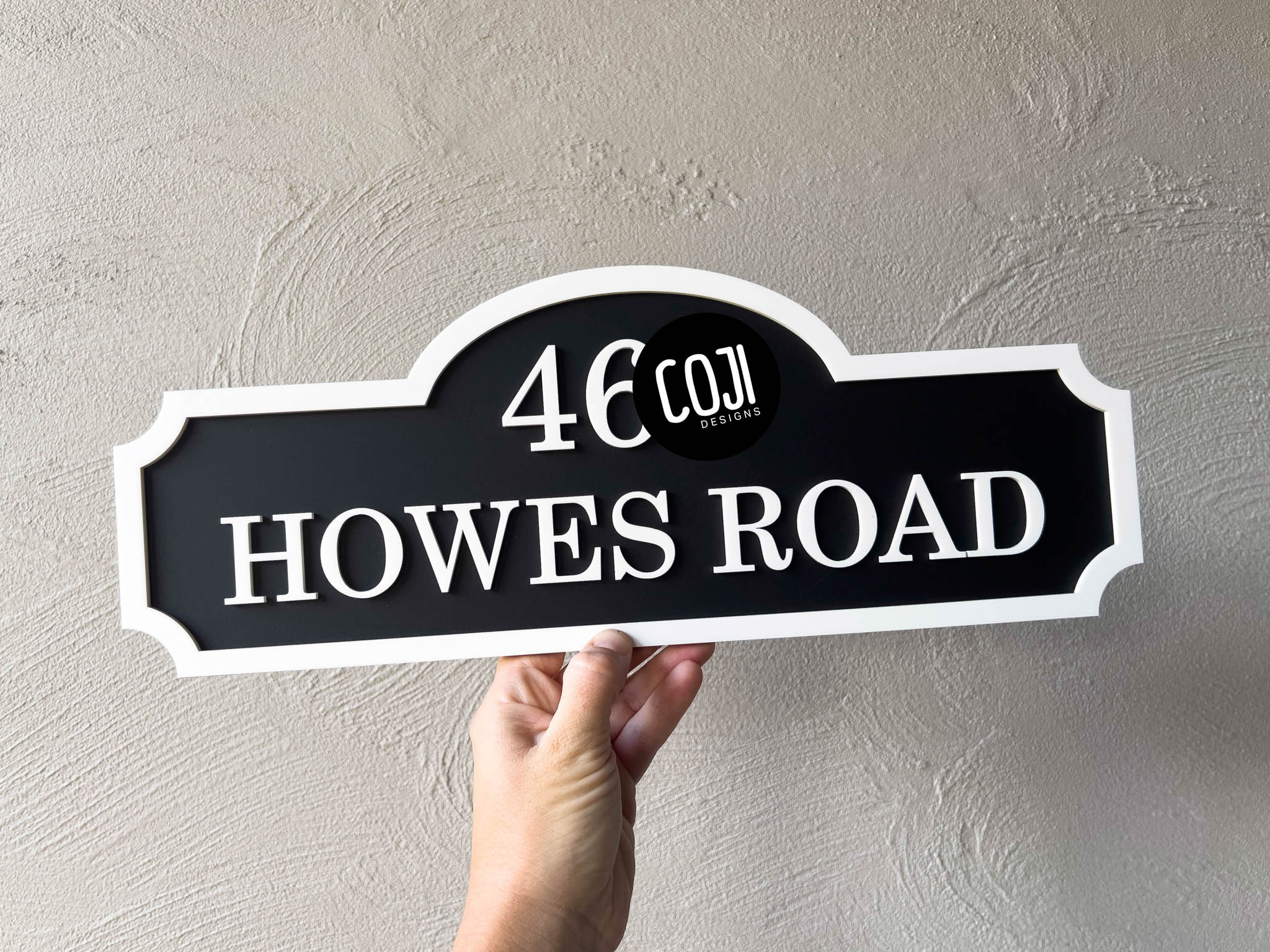 A 3D acrylic multi-layered address sign in black and white with 'HOWES ROAD'.