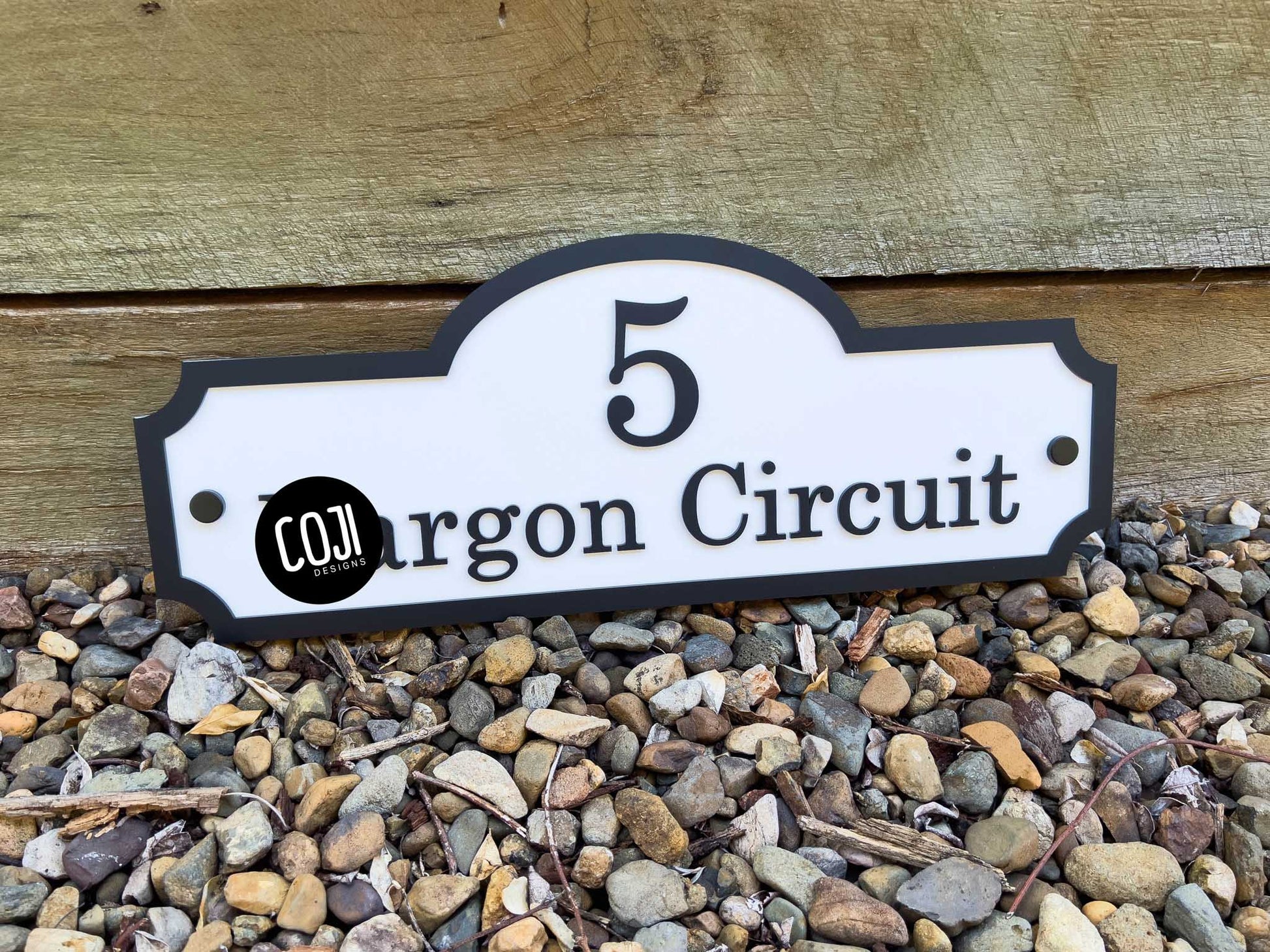 House number sign reading '5 Circuit' with a logo on a wooden background