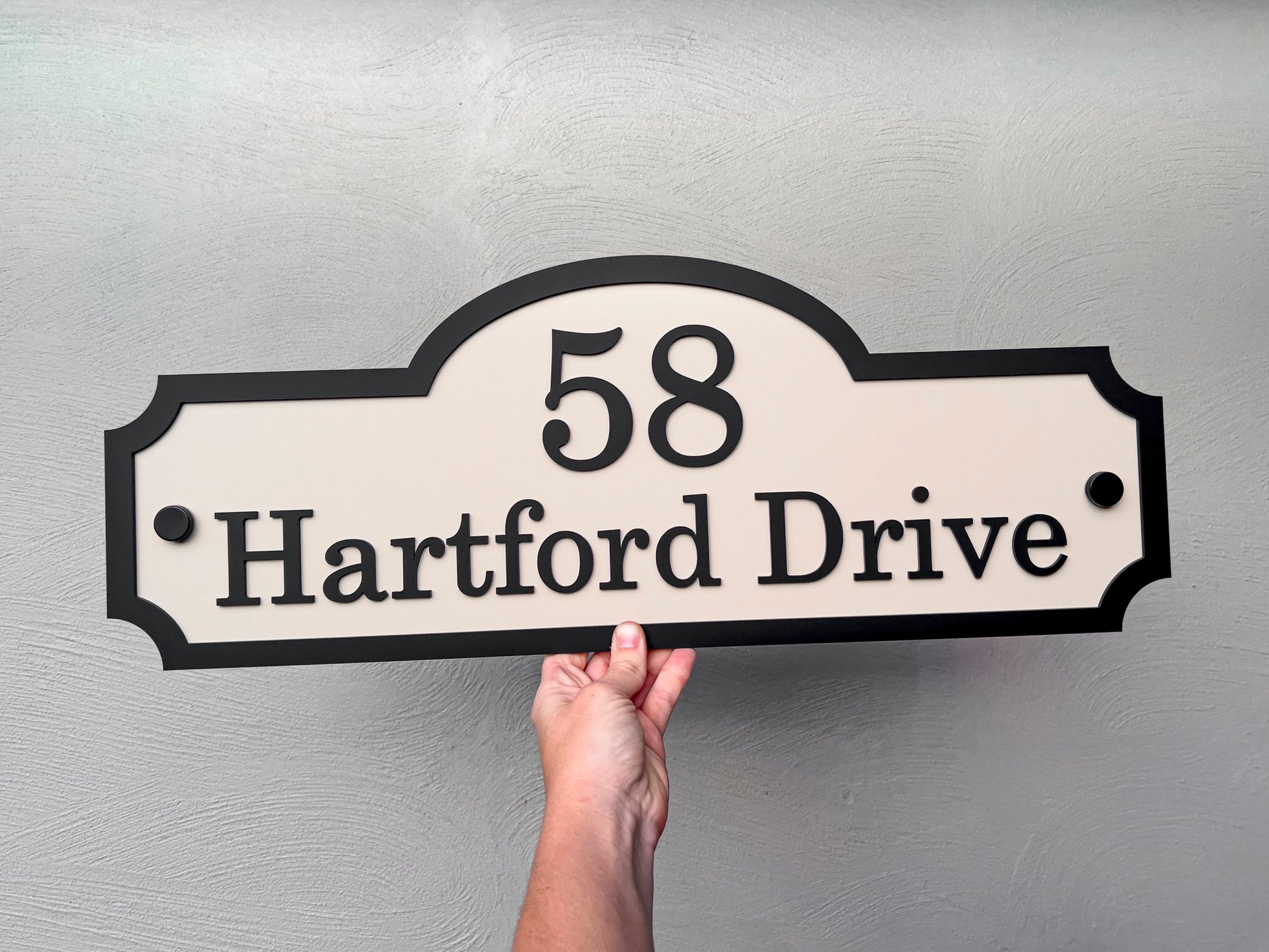 A beige and black custom made 3D acrylic sign in a heritage shape with '58 Hartford Drive'.