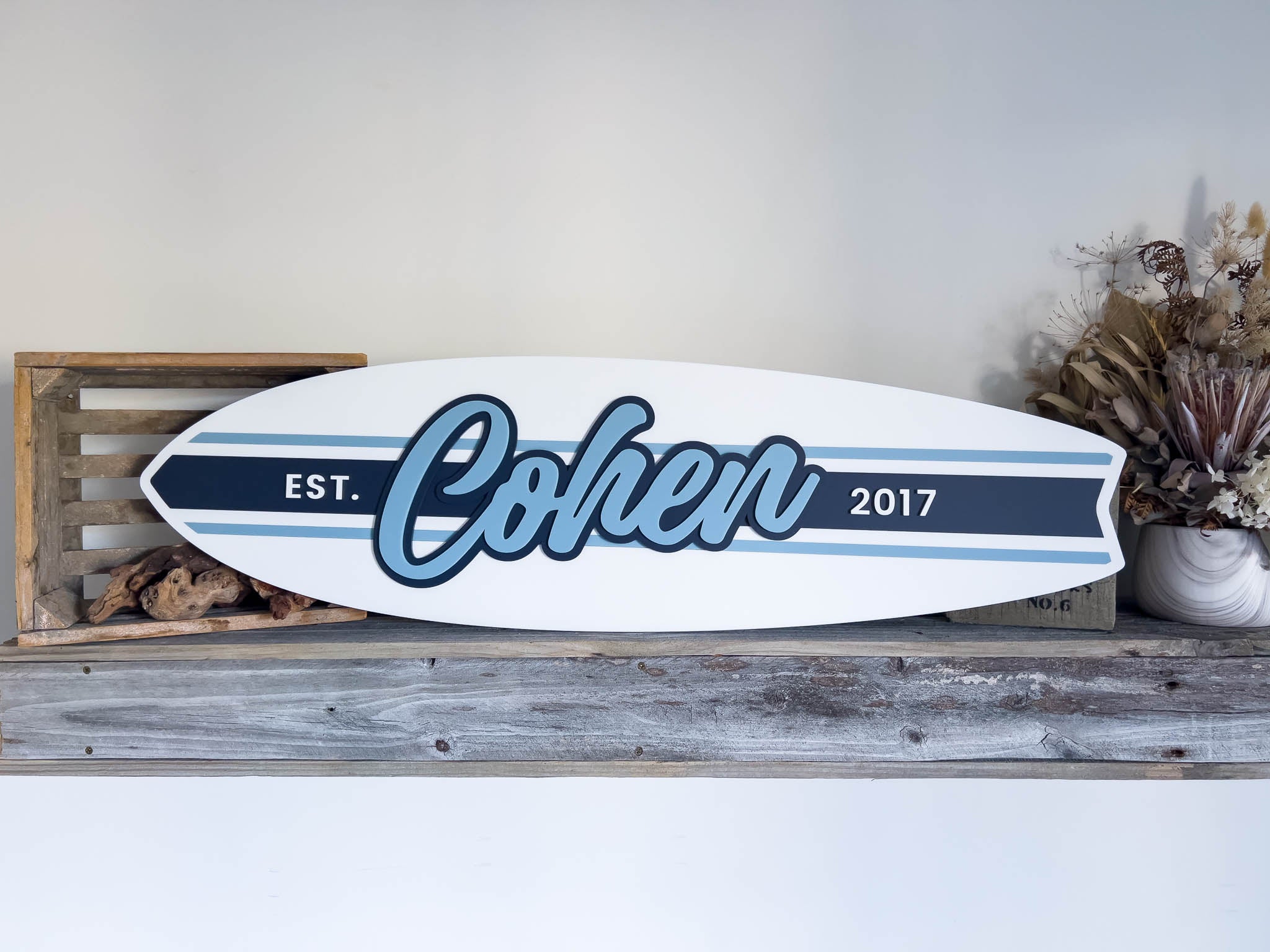 Classic surfboard style sign with racing stripes for child's bedroom that says 'Cohen' in shades of blue