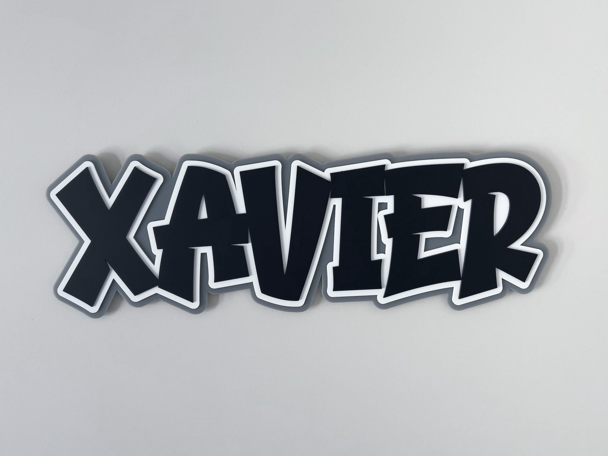 Custom retro graffiti style 3D name plaque with the name 'XAVIER' laser cut in black, white and grey.