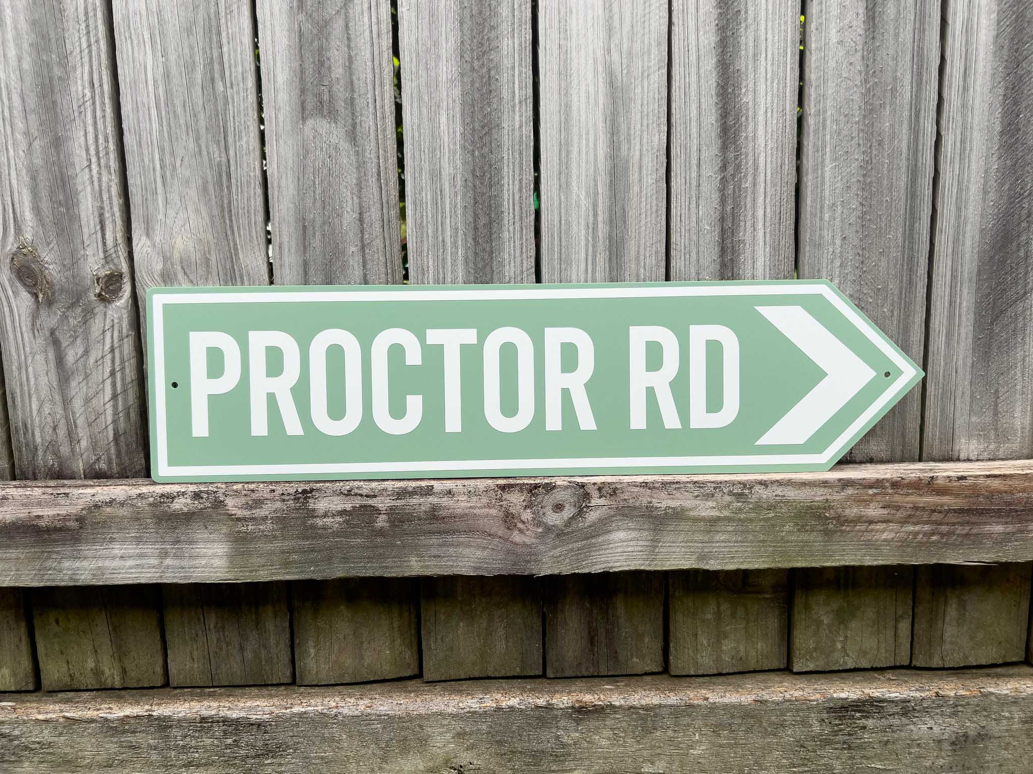 Cool retro style highway direction sign that reads 'PROCTOR RD' in mint green and white.