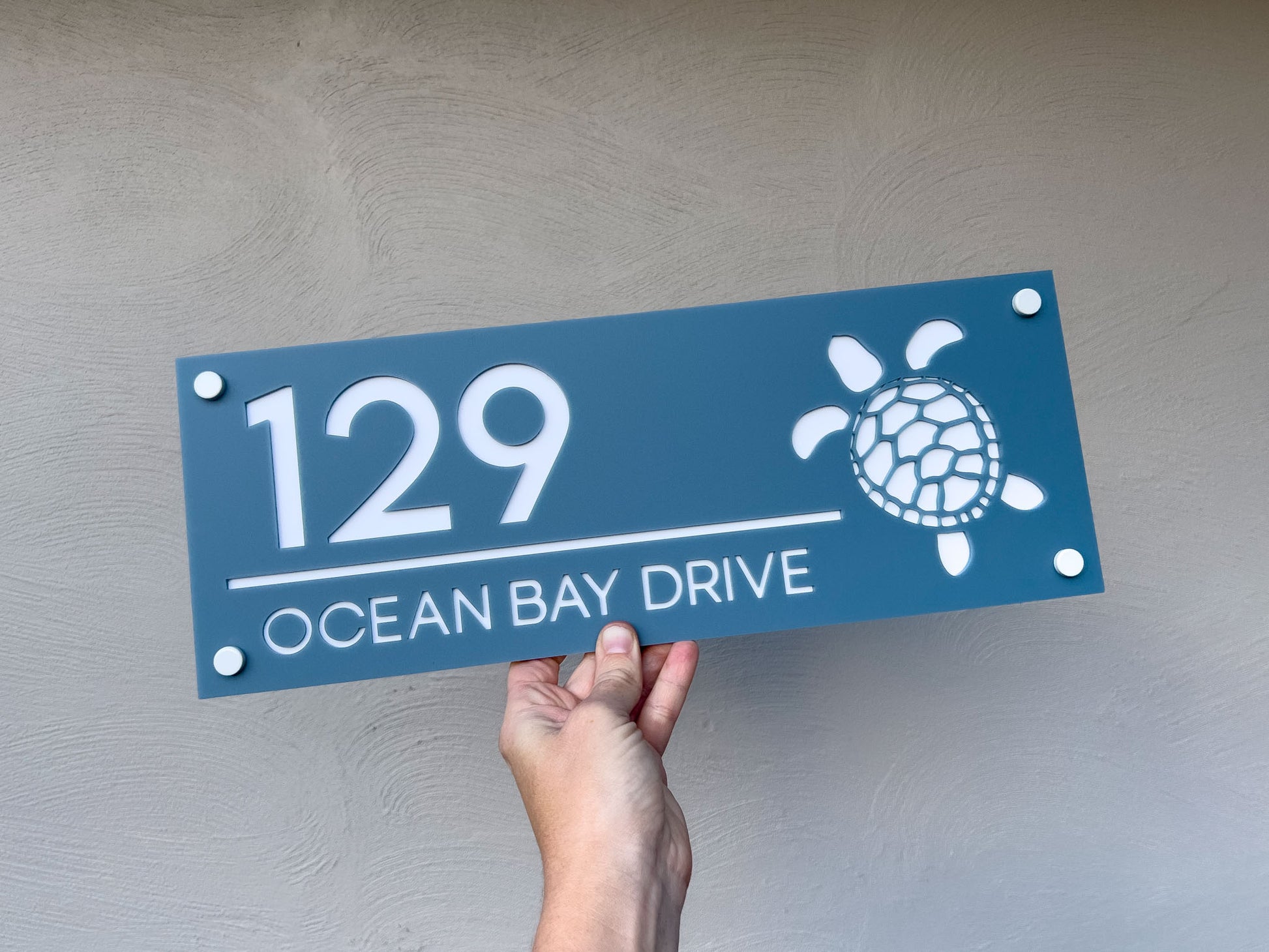 Custom laser cut 3D acrylic sign with a turtle that reads '129 Ocean Bay Drive' in a dusty sea blue and white colour