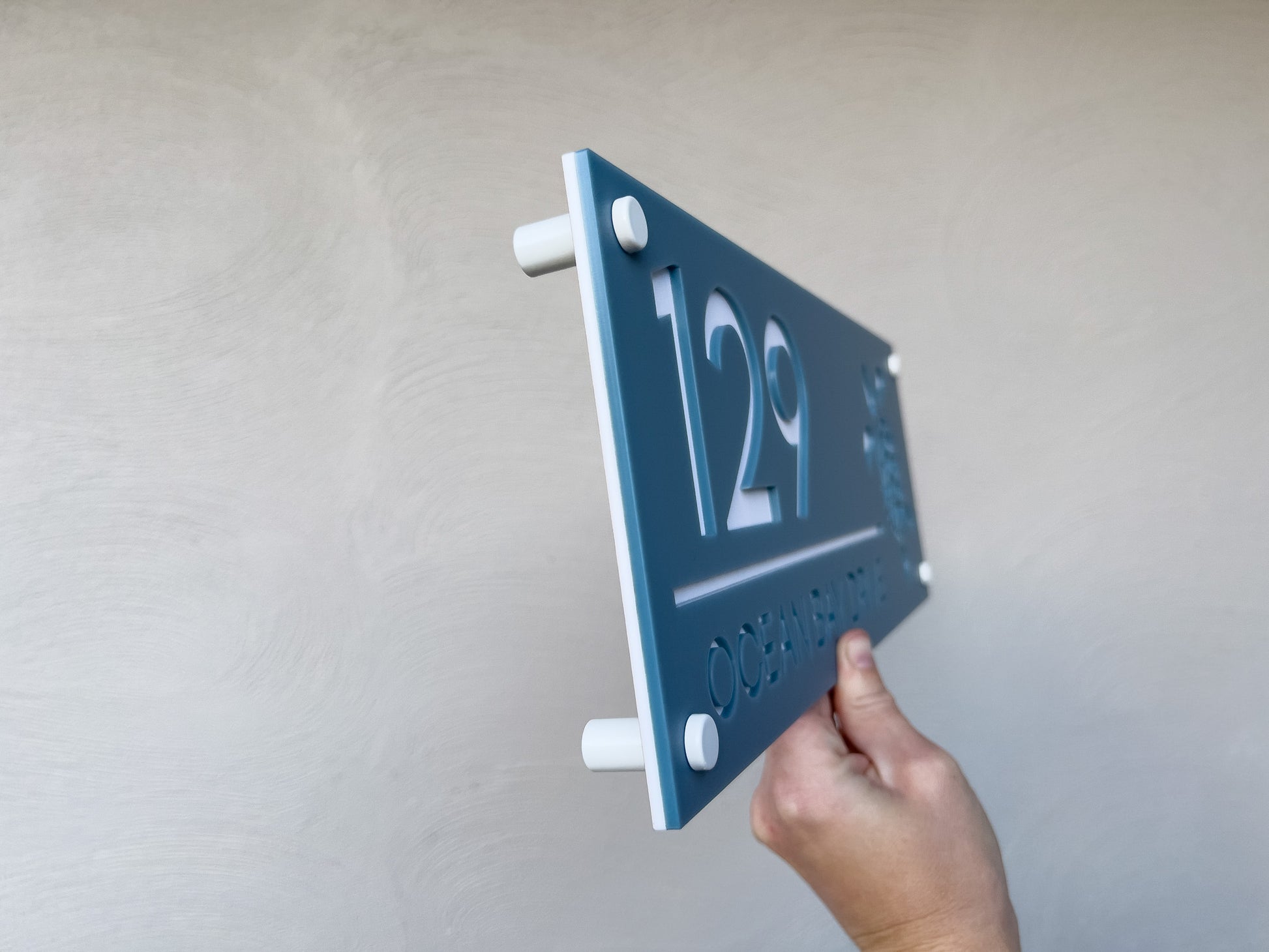 Hand holding the Honu sea turtle address sign side view
